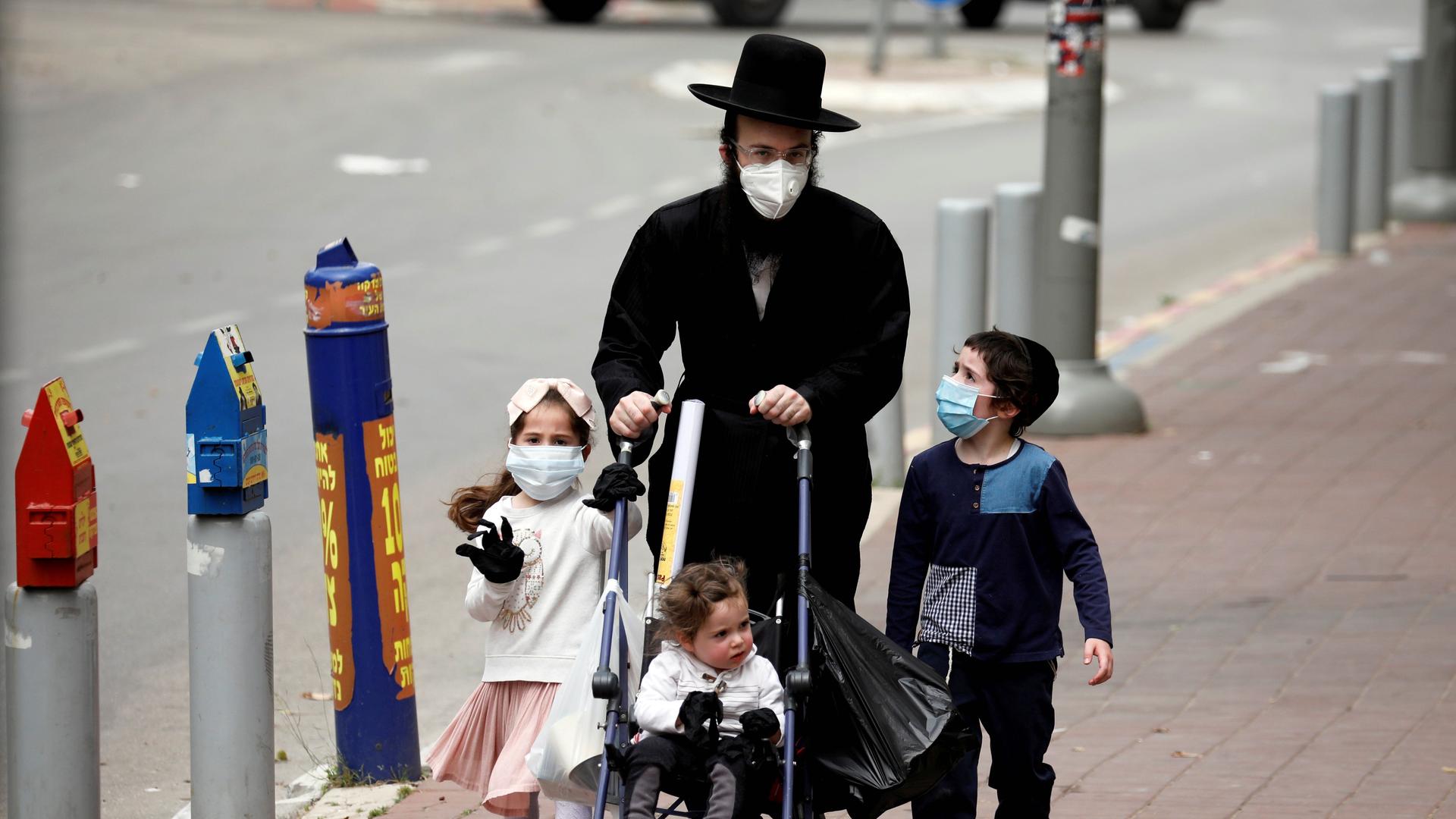 An ultra-Orthodox Jewish family wearing masks