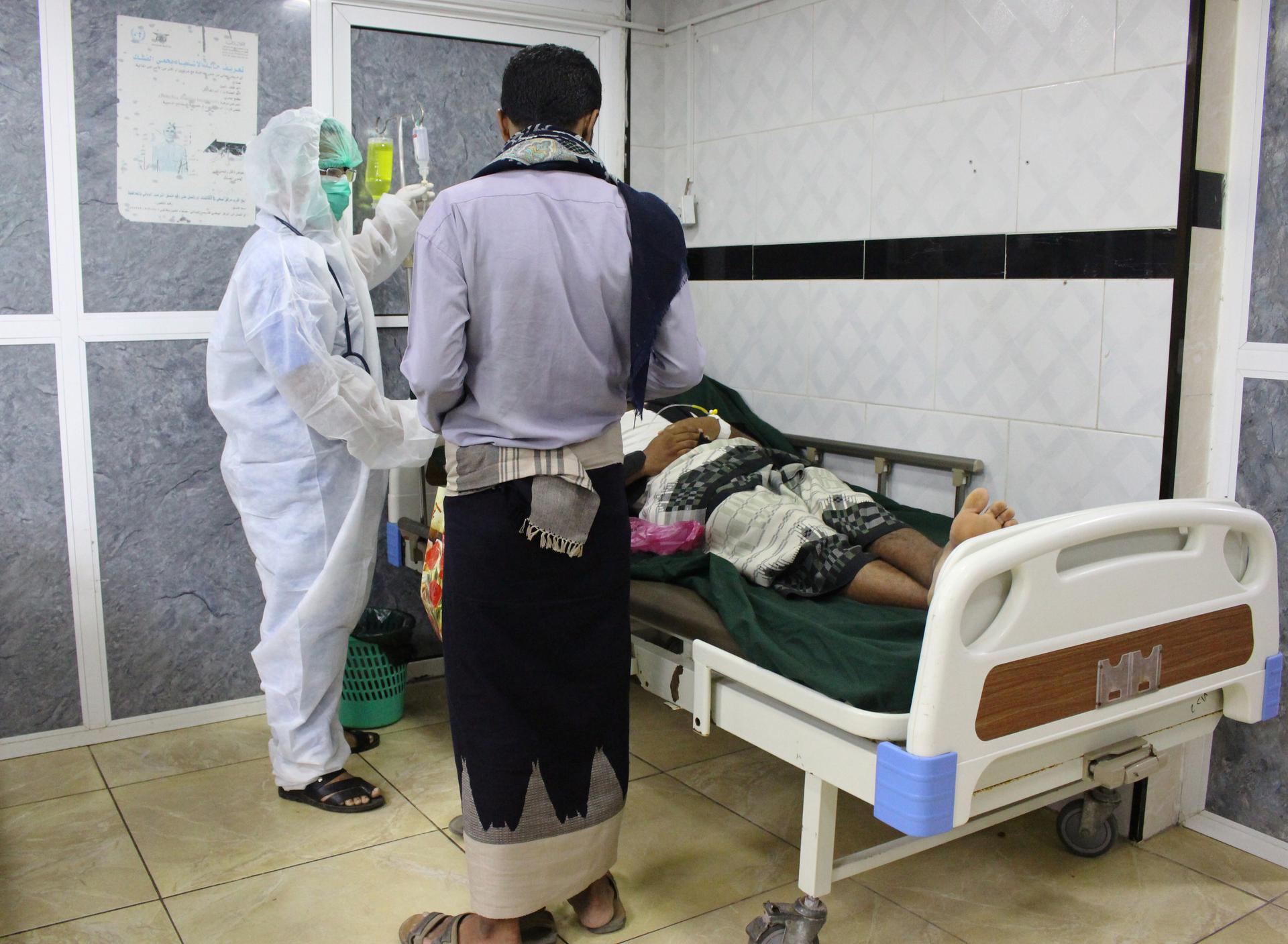 A medic wearing a protective suit attends to a patient at the emergency ward of a hospital amid concerns about the spread of the coronavirus disease, COVID-19, in Aden, Yemen