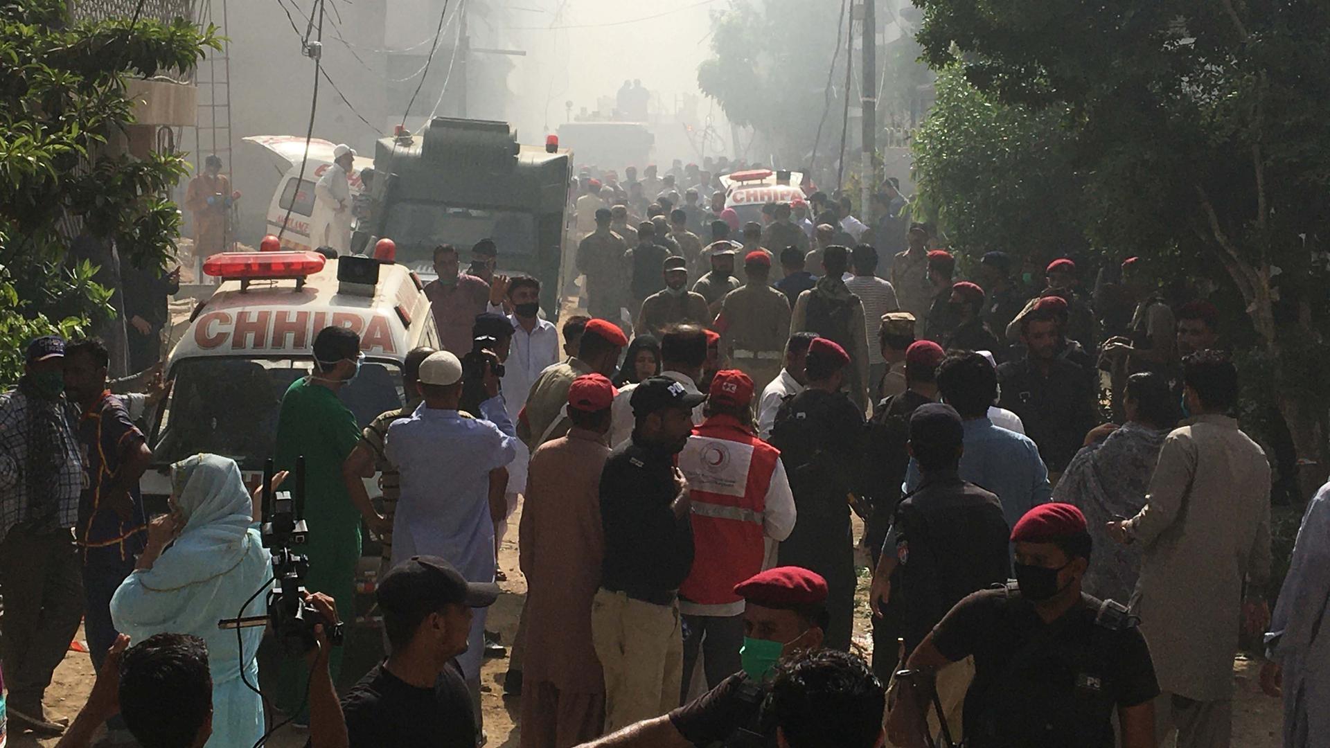 Ambulances and fire brigade vehicles gather at the site of a passenger plane crash in a residential area near an airport in Karachi, Pakistan, on May 22, 2020.