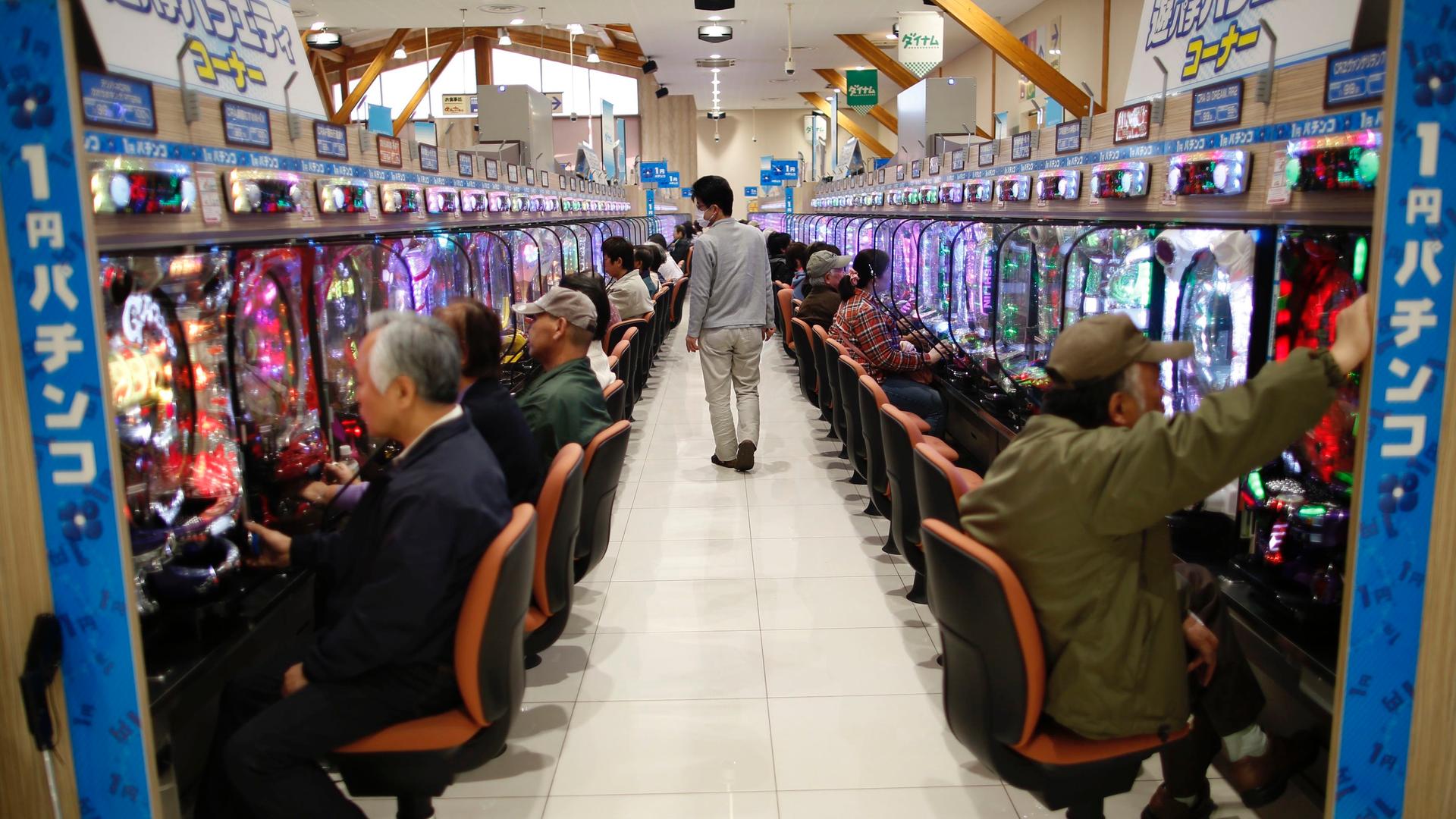 Visitors play Pachinko, a Japanese form of legal gambling, at Dynam Japan Holdings Co.'s Pachinko parlour in Koga, north of Tokyo, April 7, 2014. 
