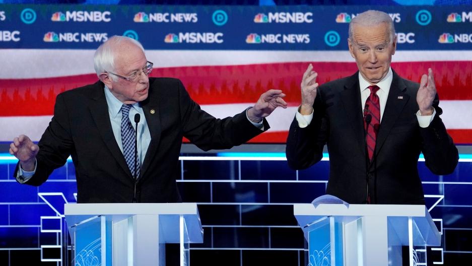 Joe Biden y Bernie Sanders speak at a debate.
