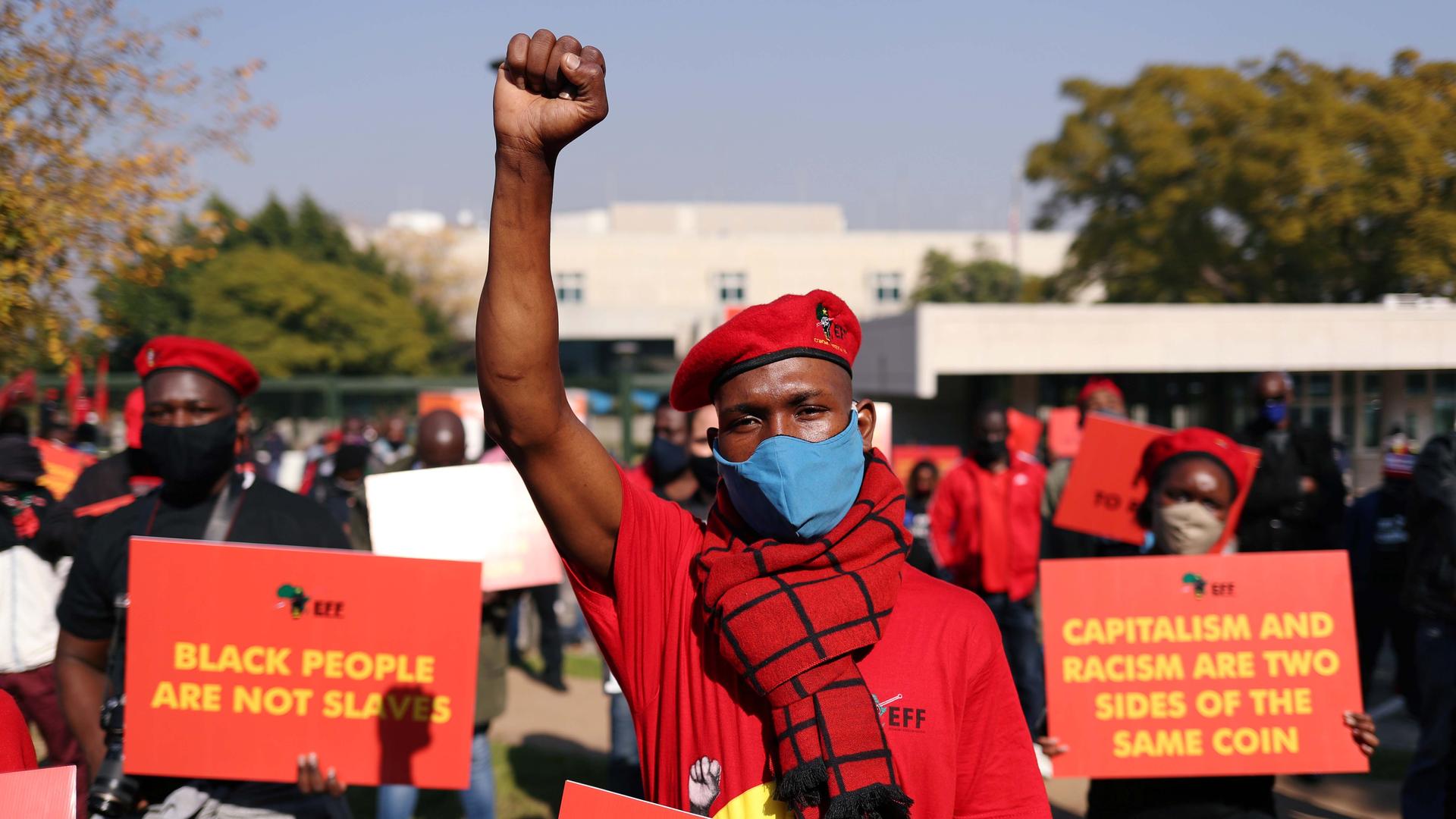 A member of South Africa's opposition party, the Economic Freedom Fighters (EFF), wears a red shirt and chants outside the US embassy in Pretoria, South Africa, on June 8, 2020. 
