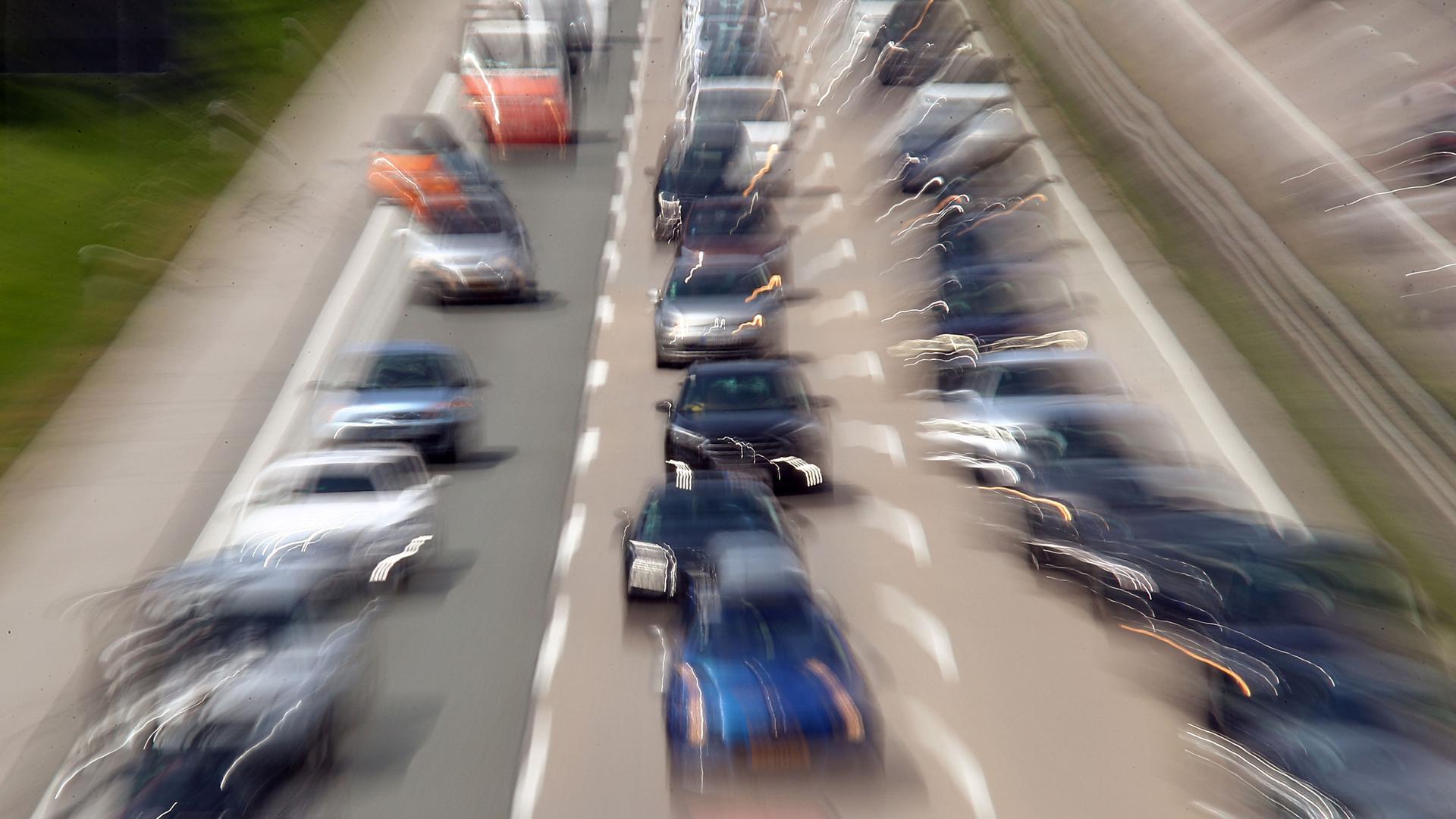 A three lane highway is shown packed with cars and taken with a blurry effect.