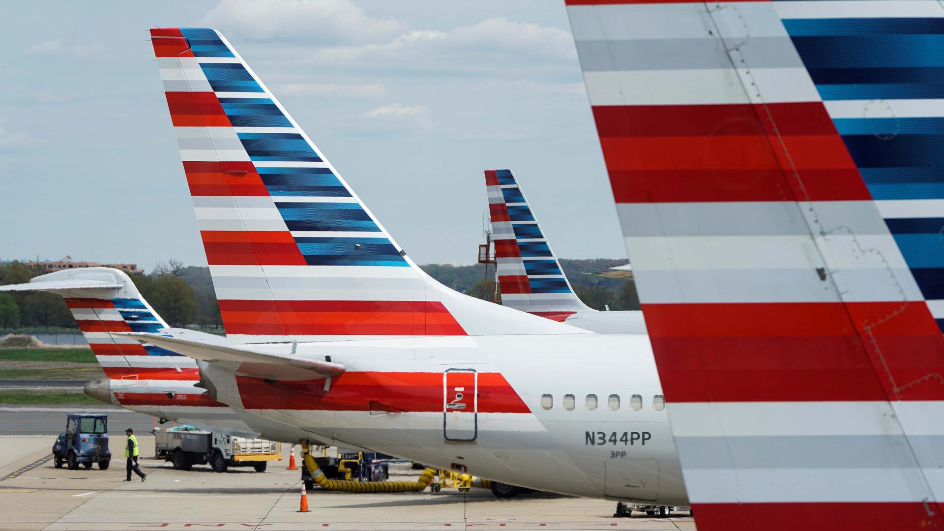 A member of a ground crew walks past American Airlines planes parked at the gate during the coronavirus disease (COVID-19) outbreak at Ronald Reagan National Airport in Washington, DC, April 5, 2020.