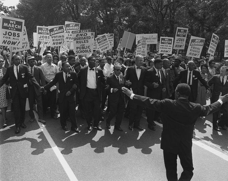 Leaders at the head of the Civil Rights March on Washington, DC, wearing suits and carrying signs.