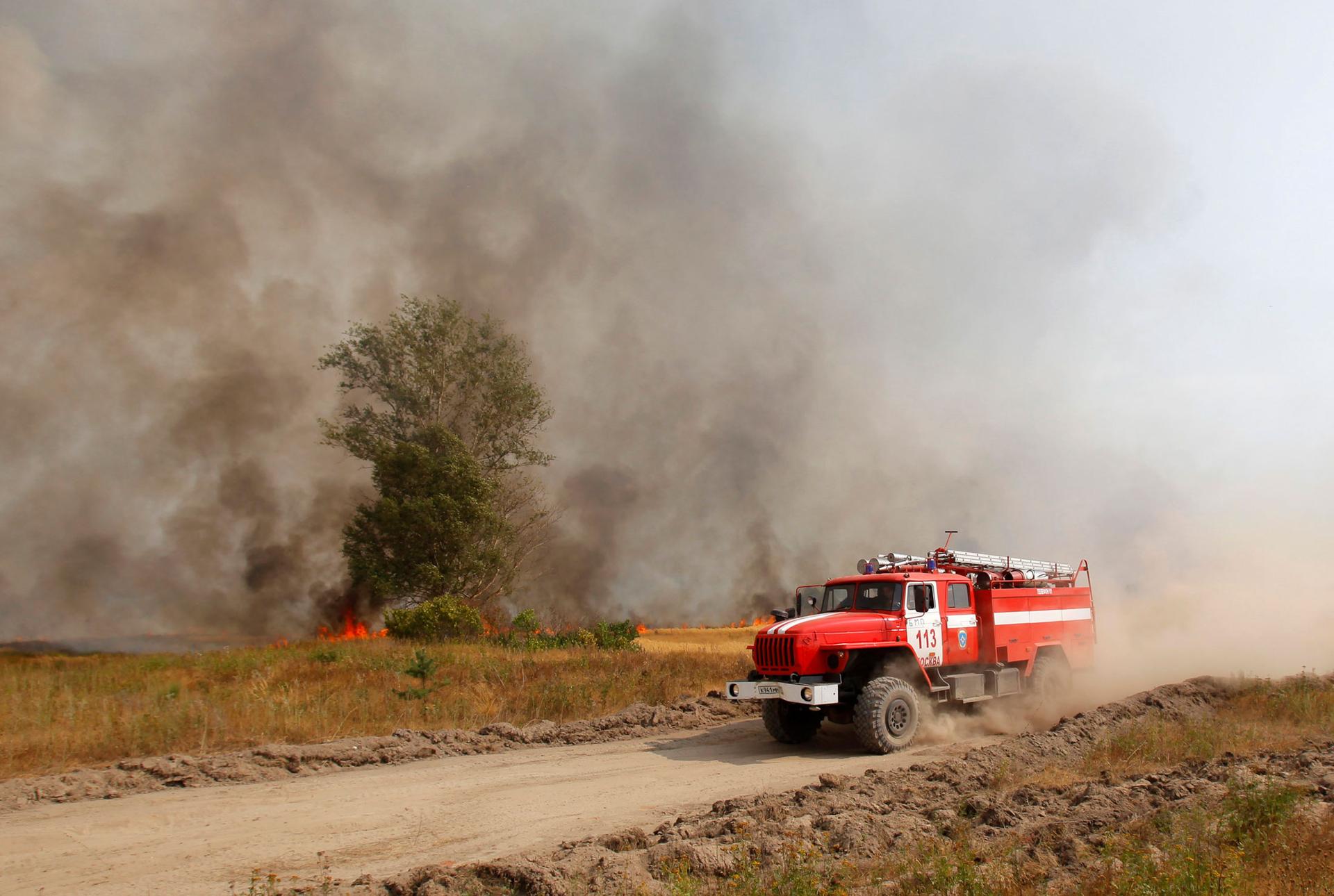 A red fire truck is shown driving across the frame with smoke and fire in the background.
