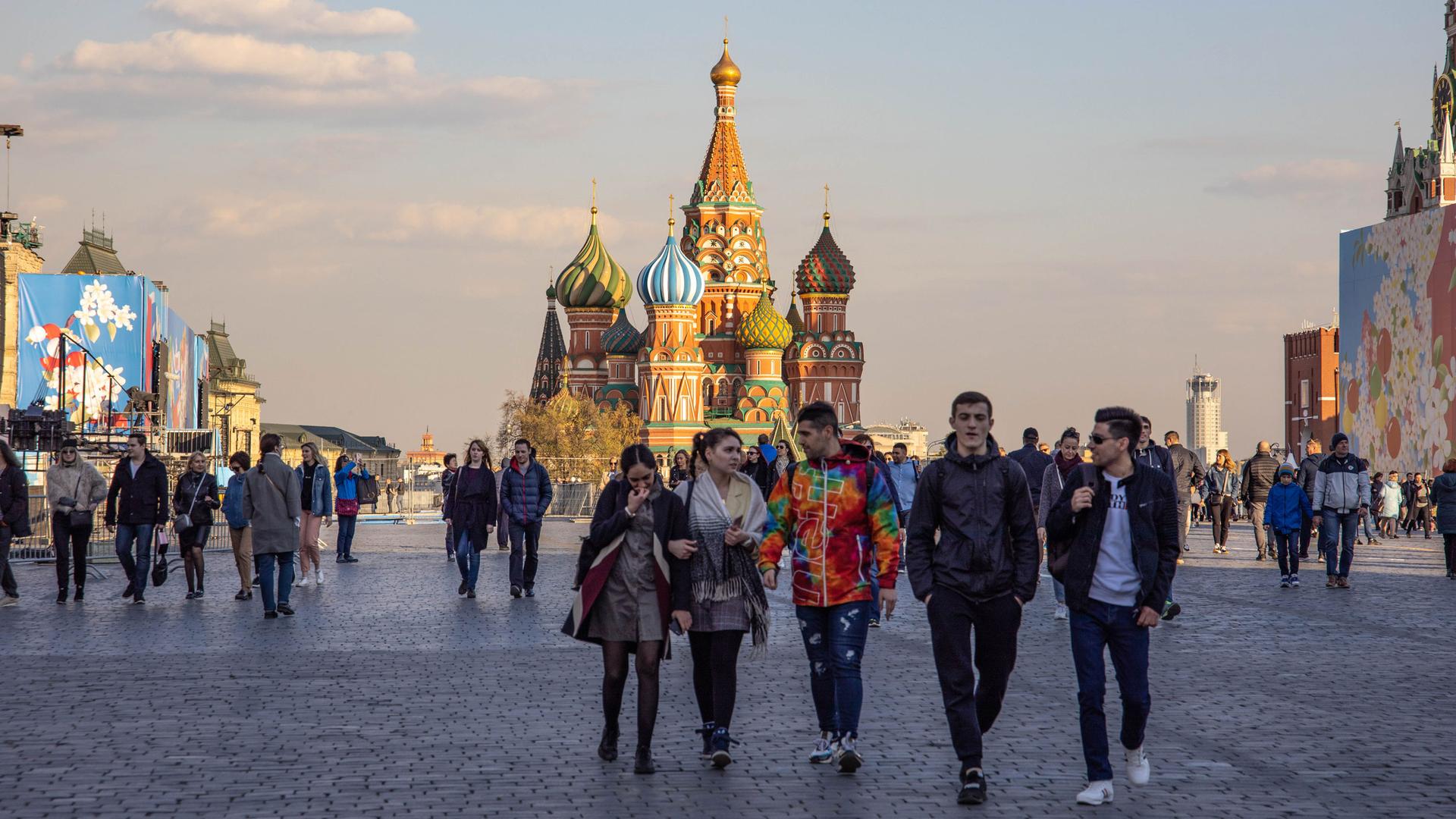 People walk through Red Square in Moscow. St. Basil's Cathedral is in the distance. 
