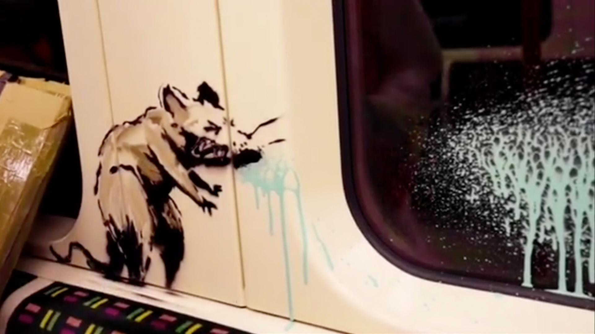 A stenciled rat appears to be sneezing.