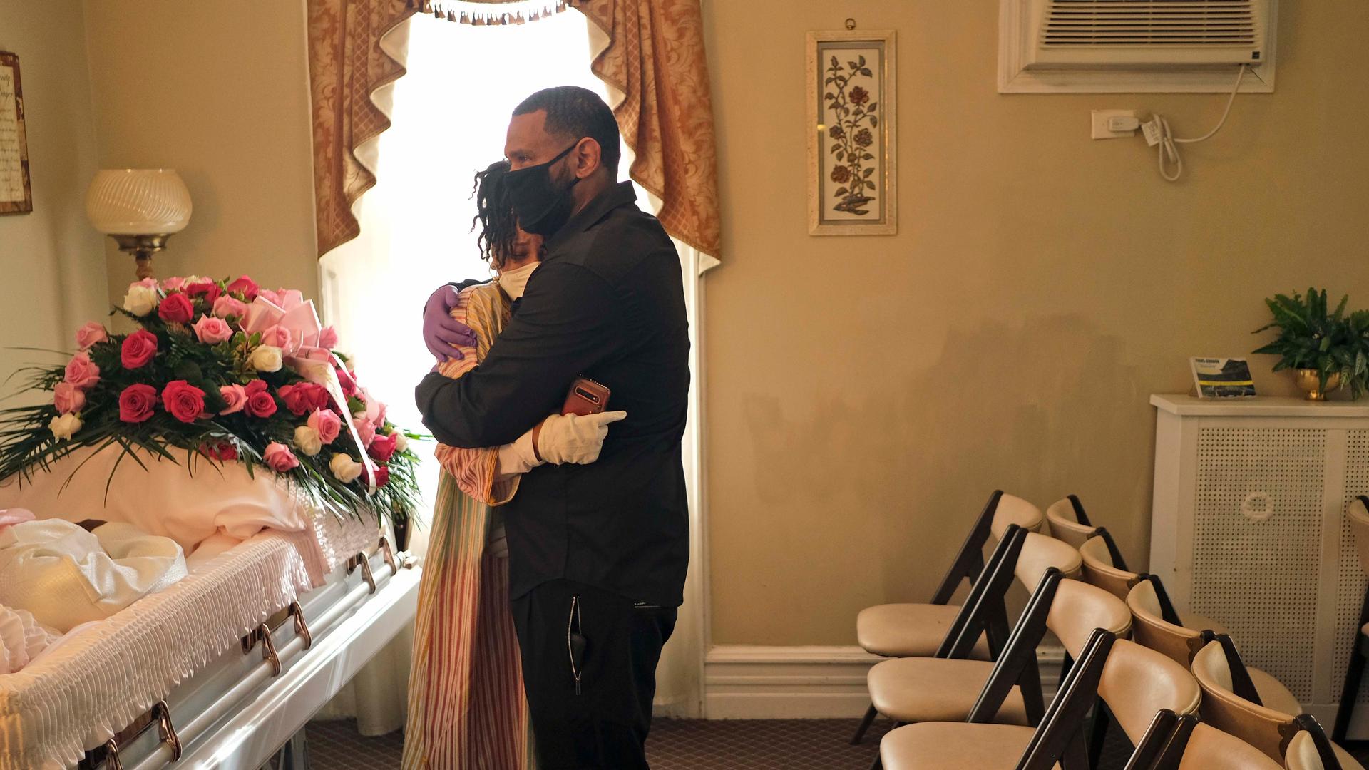 Siblings Erika and Dwayne Bermudez comfort one another during a short viewing of their mother, Eudiana Smith, at The Family Funeral Home, May 2, 2020, in Newark, New Jersey. 