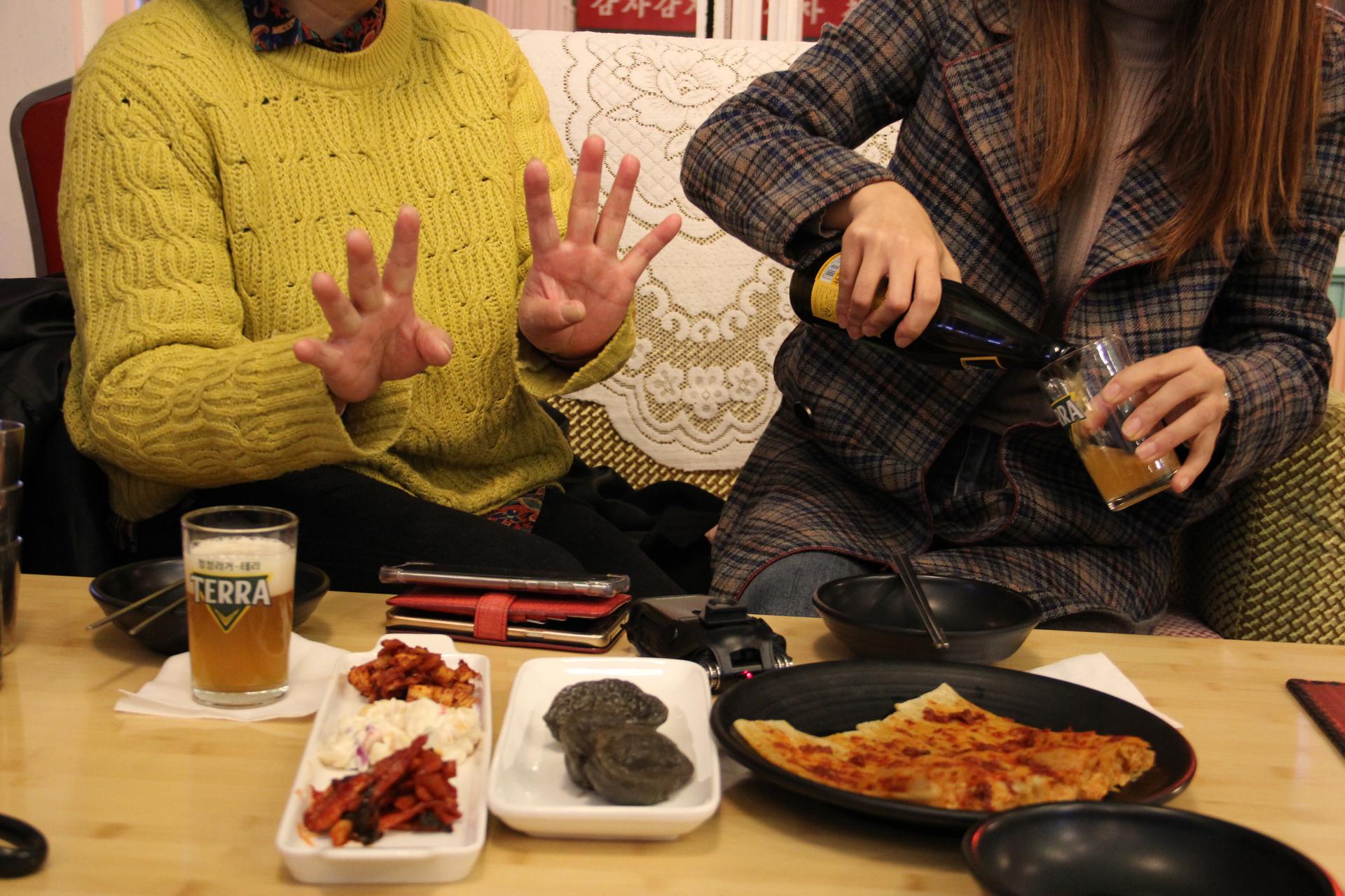 Kim Eun-joo (right) does Han (left) the courtesy of pouring a glass of beer before they begin eating dinner.