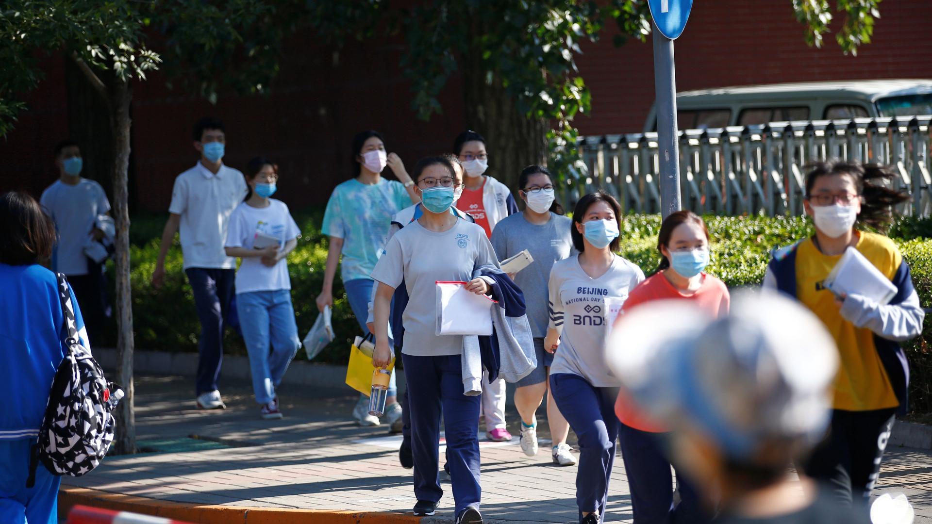 Students wearing face masks walk in line to enter a high school as they take part in the annual national college entrance exam, or "gaokao", which has been postponed by one month due to the coronavirus disease (COVID-19) outbreak, in Beijing, China July 7
