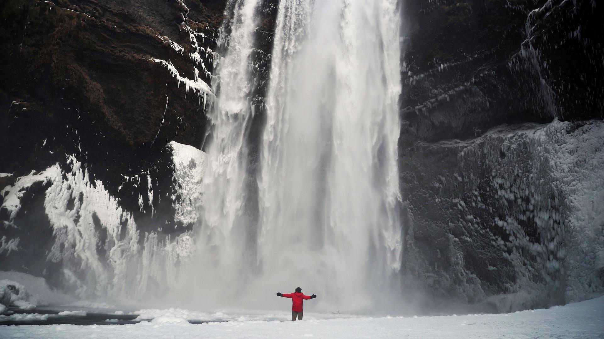 A man stands in front of the Skogafoss waterfall in Skogar, Iceland, March 8, 2020. 