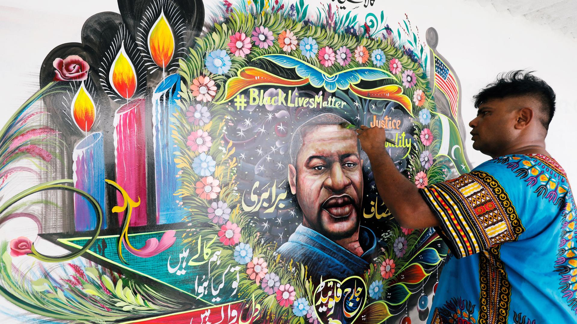 Pakistani truck-art painter Haider Ali, 40, touches up a mural depicting George Floyd in Karachi, Pakistan, June 12, 2020. 