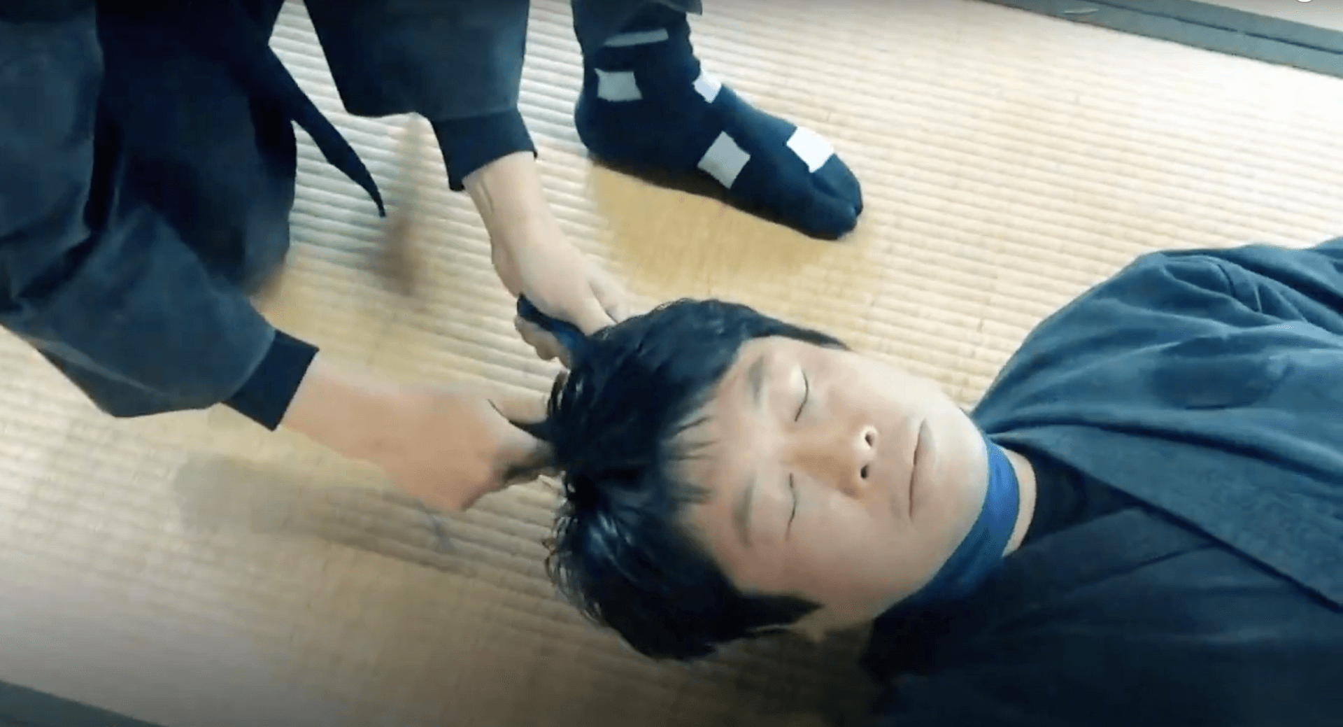 Ninja studies expert Mitsuhashi Genichi is choked with a cloth during a martial arts training session.