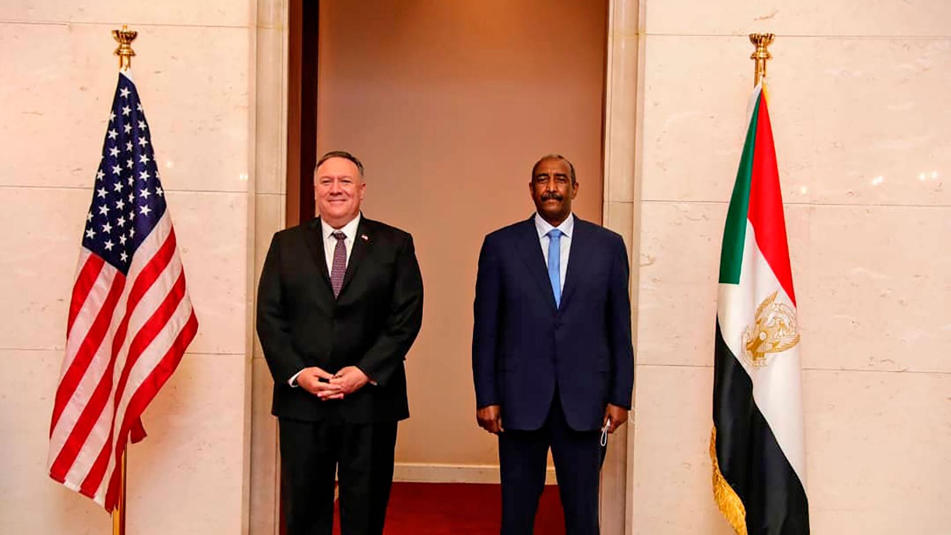 US Secretary of State Mike Pompeo is shown standing with Sudanese Gen. Abdel-Fattah Burhan with the US and Sudanese flags on either side.