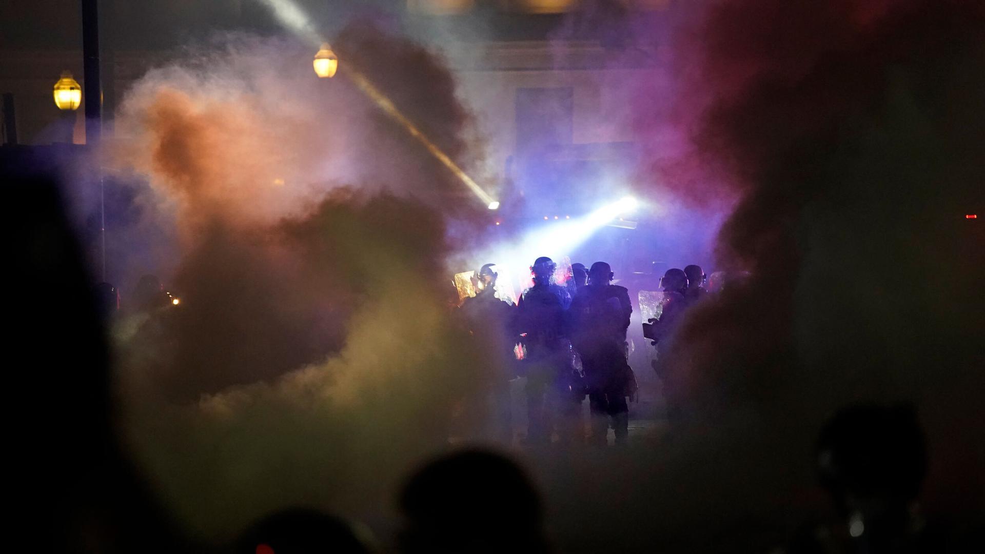 Police in riot gear clear the area in front of Kenosha County Courthouse during clashes with protesters in Kenosha, Wisconsin, Aug. 25, 2020.