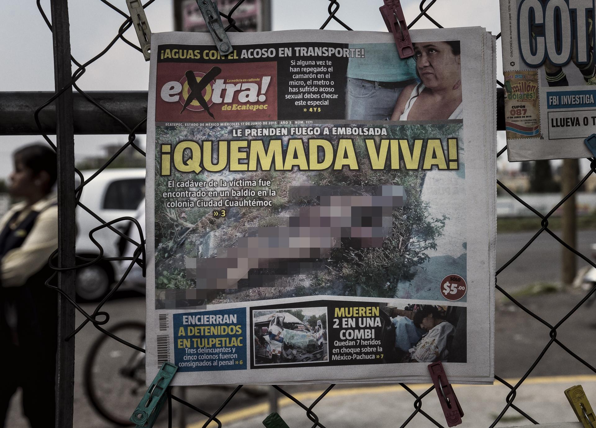 The front page of a newspaper displayed on a fence.