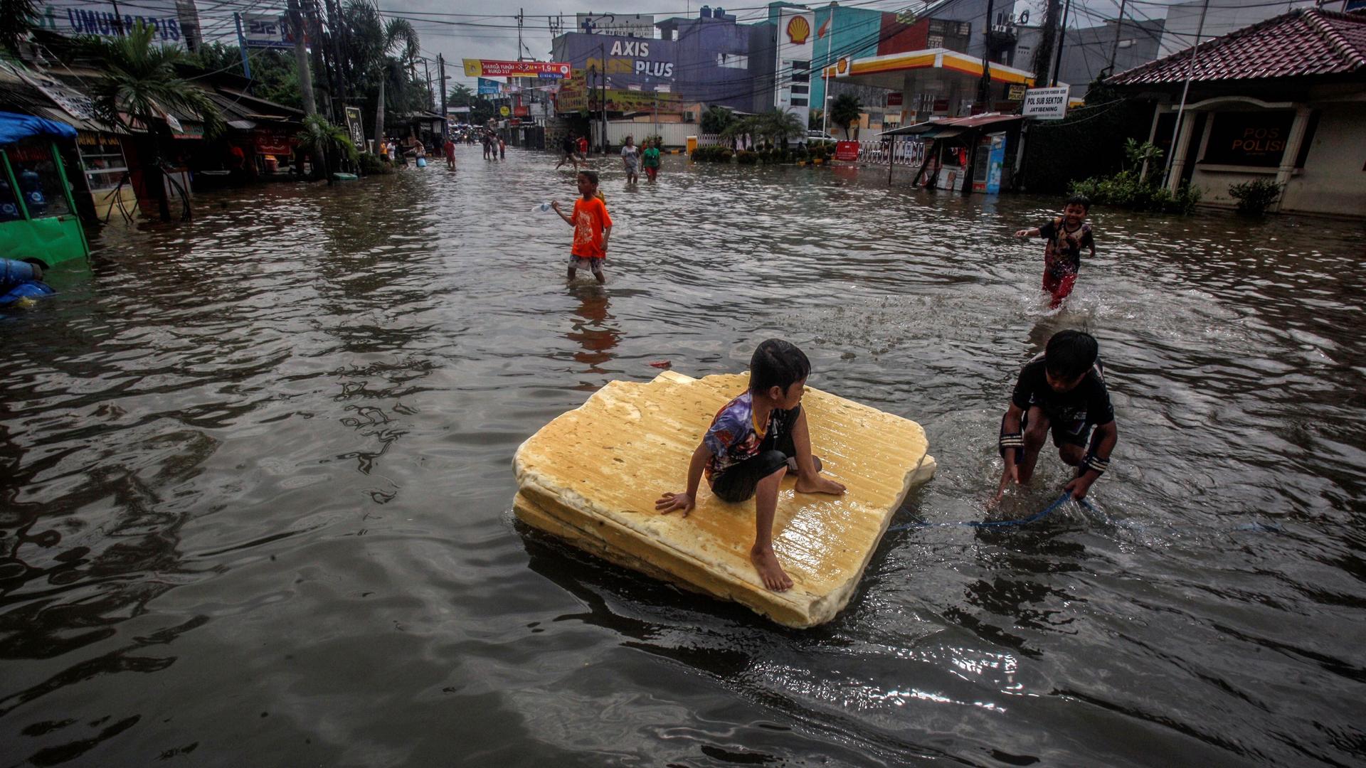 Children play in the floodwaters after heavy rains in Bekasi, near Jakarta, Indonesia, Feb. 25, 2020.