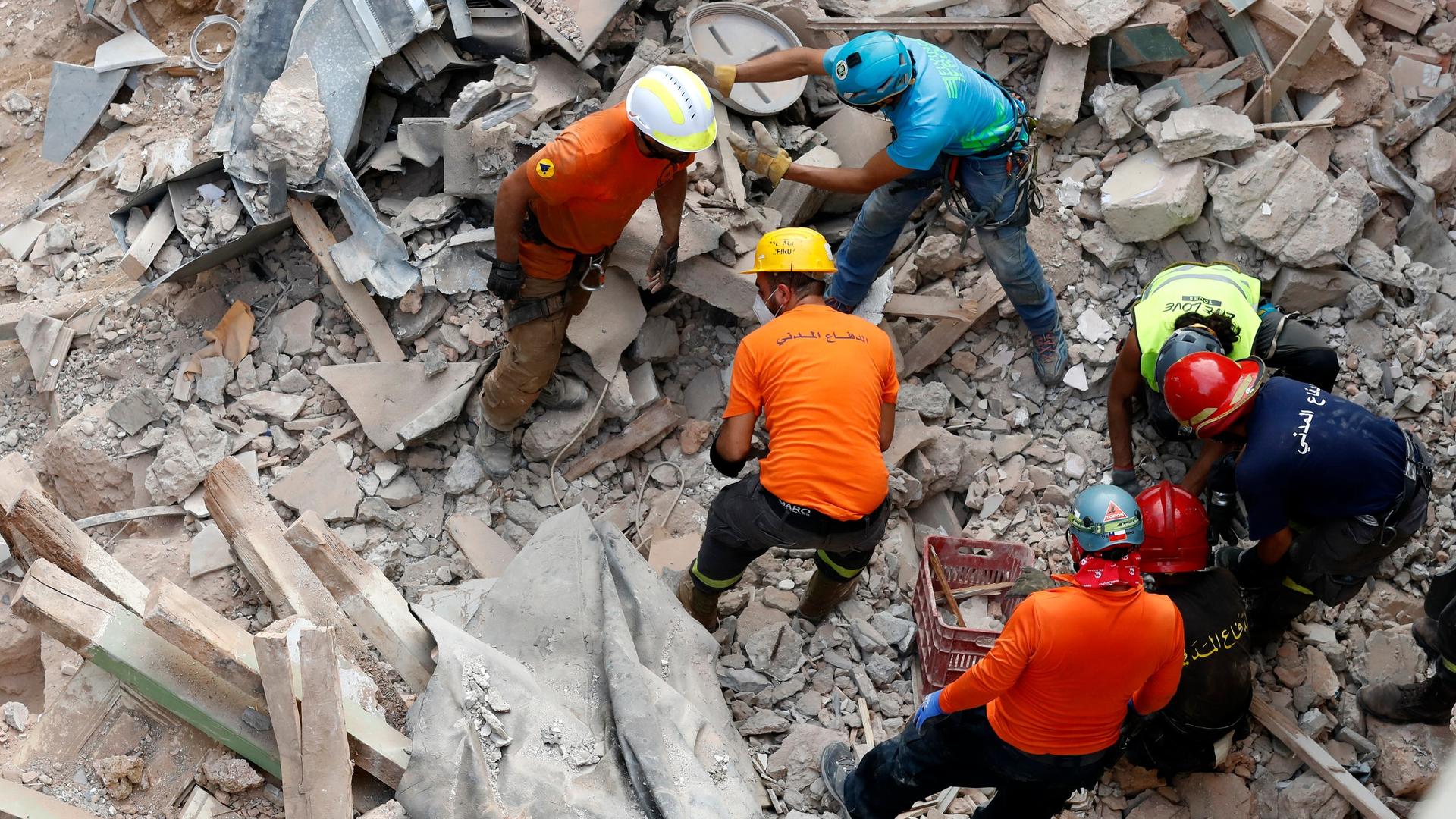 Lebanese and Chilean rescuers search at he site of a collapsed building after getting signals there may be a survivor under the rubble, in Beirut, Lebanon, Sept. 4, 2020.