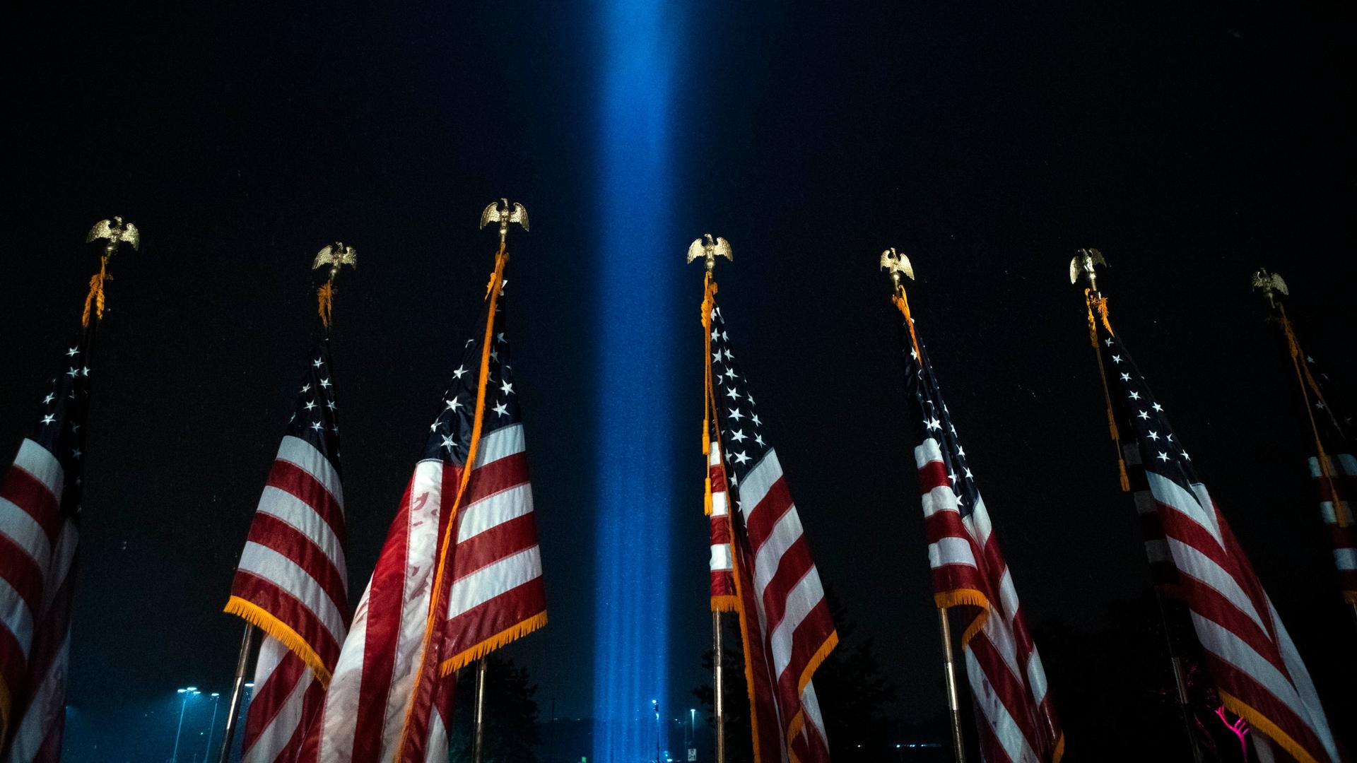 Beams of light are seen over American flags at the Pentagon, as part of a tribute marking the 19th anniversary of the 9/11 attack on the Pentagon, Sept. 9, 2020, in Washington, DC.