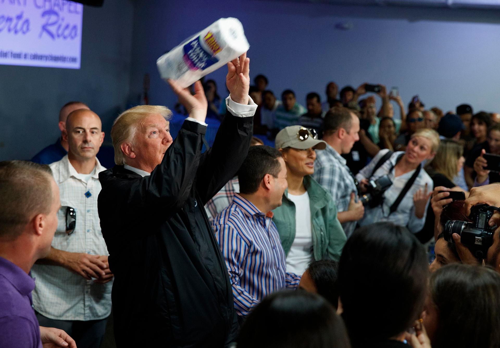 In this Oct. 3, 2017, file photo, President Donald Trump tosses paper towels into a crowd at Calvary Chapel in Guaynabo, Puerto Rico, after Hurricane Maria devastated the region.