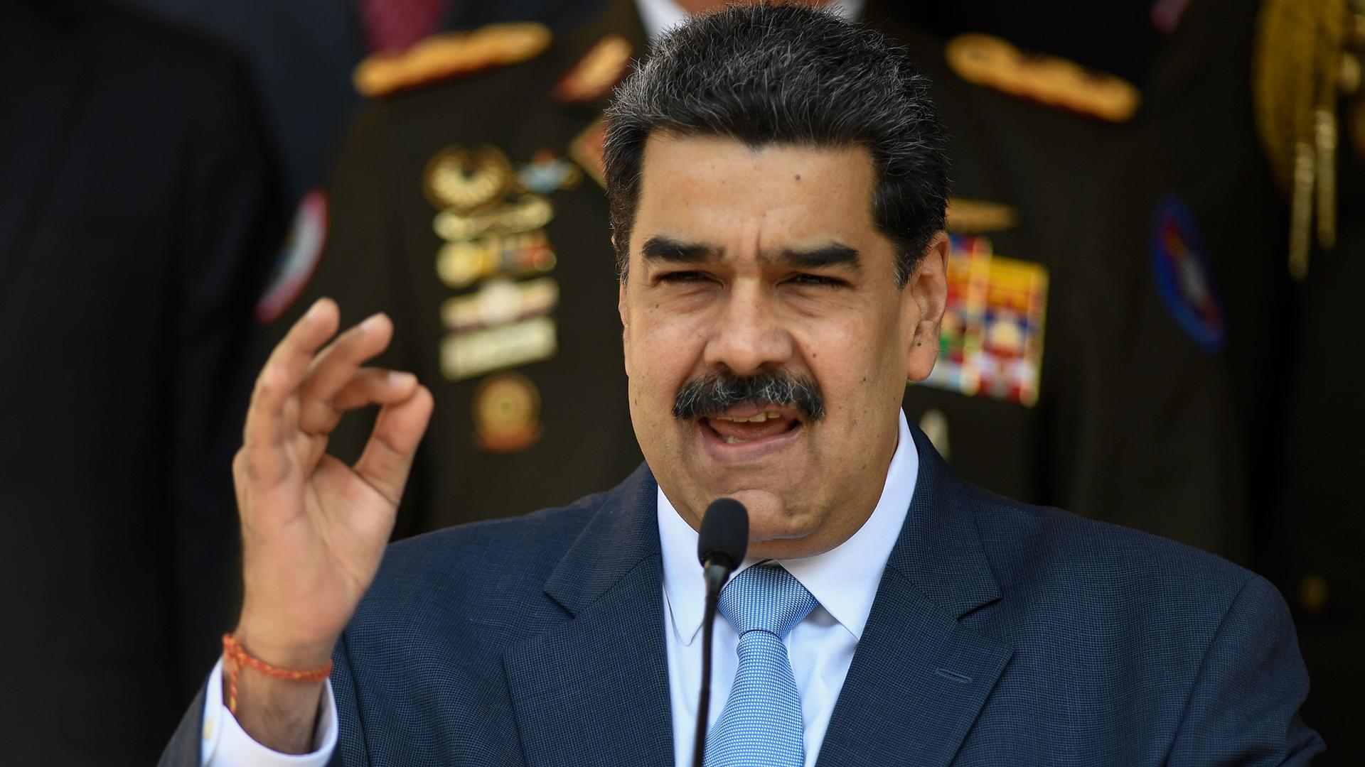Venezuelan President Nicolás Maduro is shown speaking with his right hand rised.