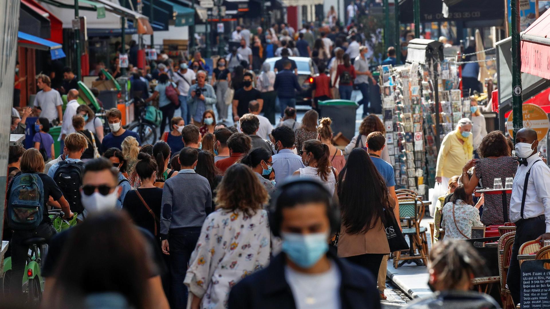 People wearing protective face masks walk in a busy street in Paris as France reinforces mask-wearing in public places as part of efforts to curb a resurgence of the coronavirus disease (COVID-19) across Europe, Sept. 18, 2020.