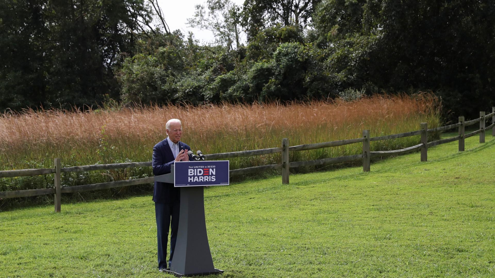 Standing in a grassy field, Joe Biden speaks about climate change during a campaign event held outside the Delaware Museum of Natural History in Wilmington, Delaware, Sept. 14, 2020.