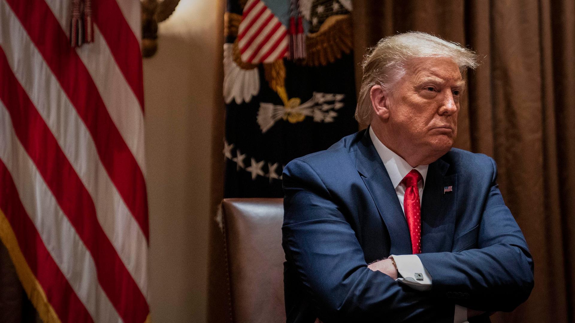 President Donald Trump crosses his arms as he listens during a White House meeting with Hispanic leaders, July 9, 2020, in Washington, DC.