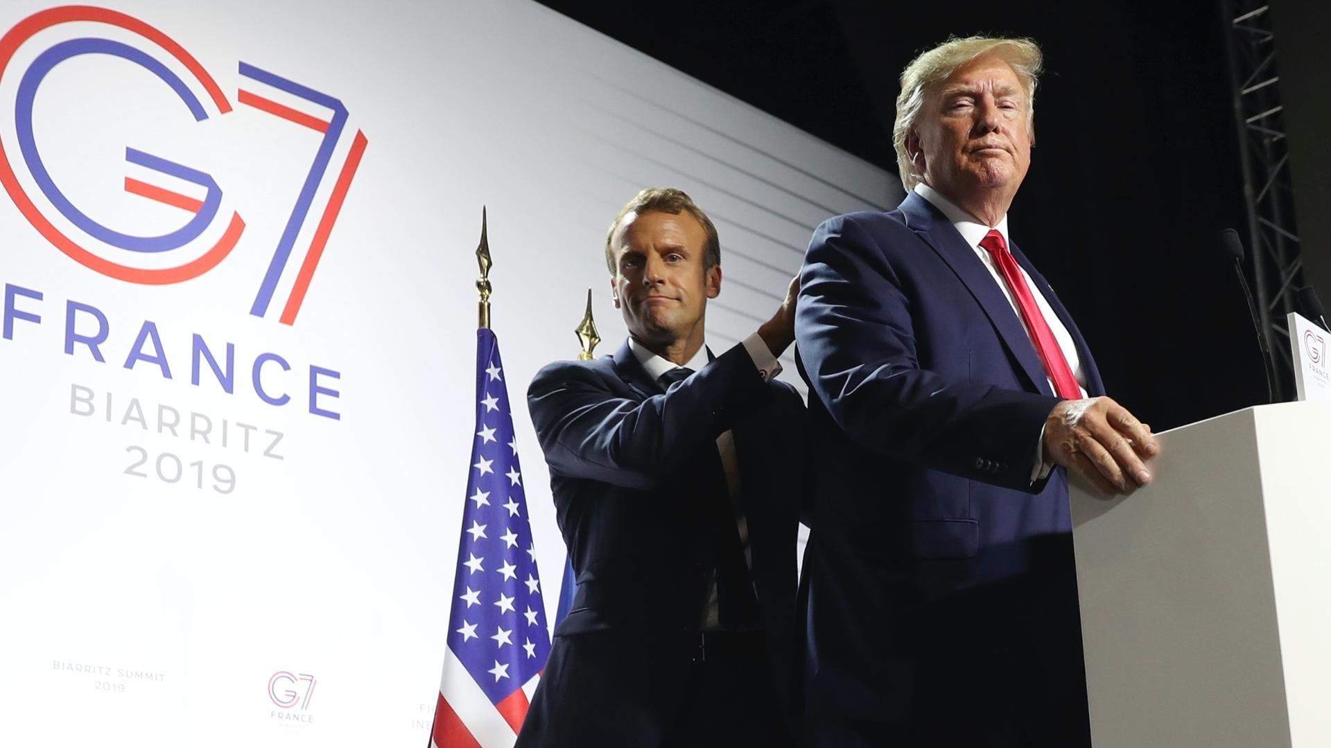 Macron and Trump stand near a podium