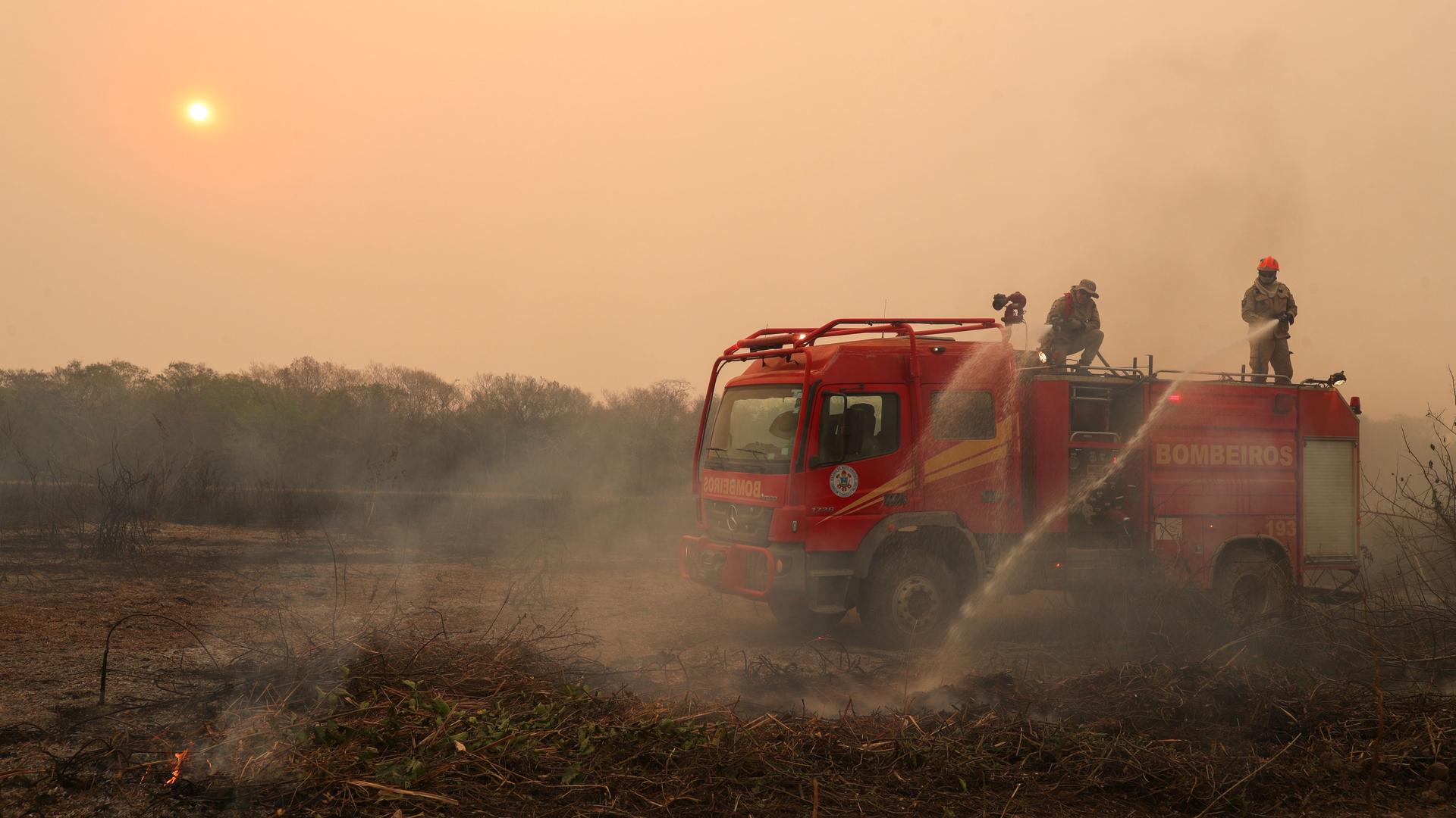 Firefighters work to extinguish a fire in a ranch amongst smoke in the Pantanal, the world's largest wetland, in Pocone, Mato Grosso state, Brazil, Aug. 28, 2020.  
