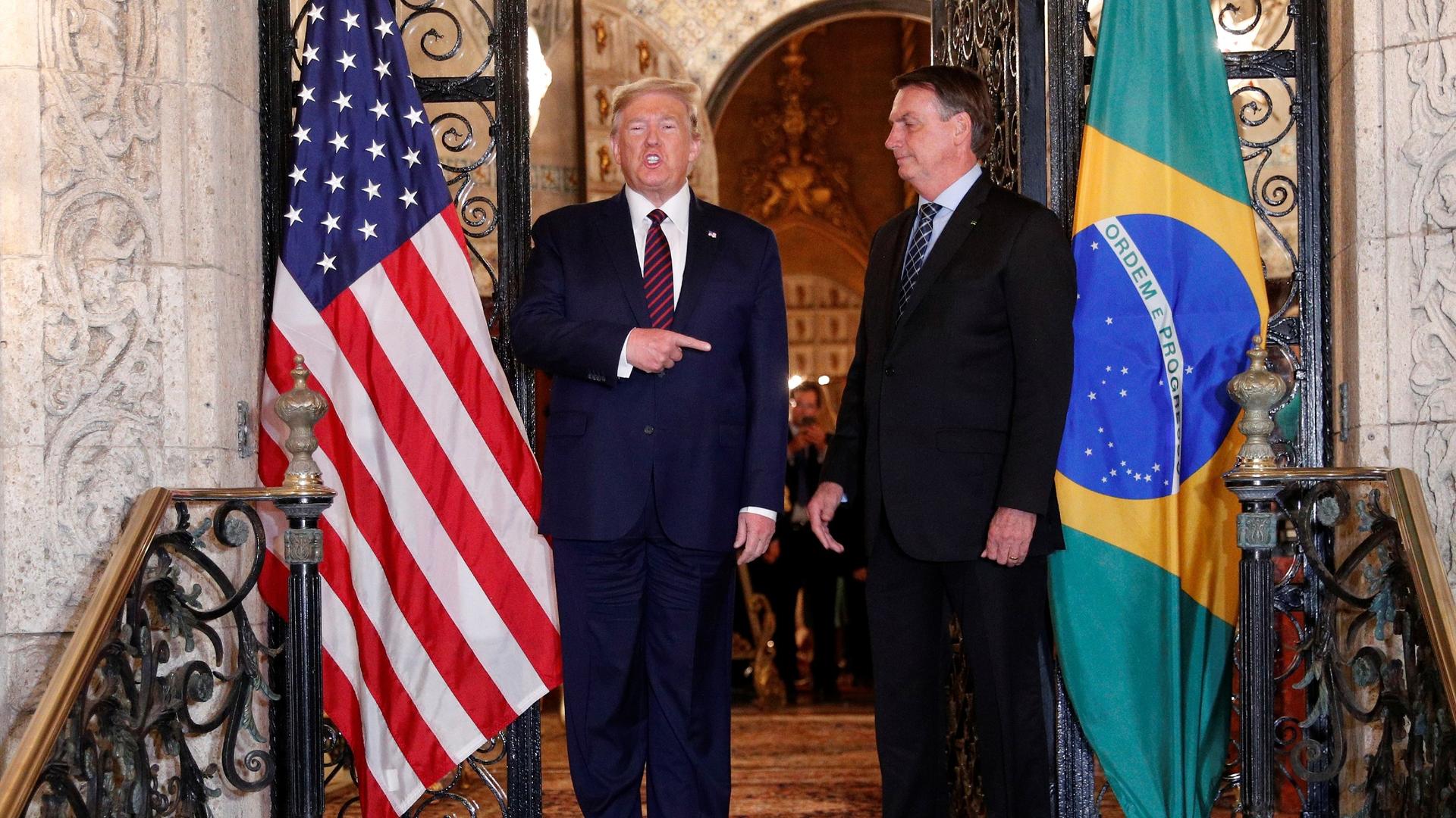 US President Donald Trump points at Brazilian President Jair Bolsonaro before attending a working dinner at the Mar-a-Lago resort in Palm Beach, Florida, March 7, 2020.