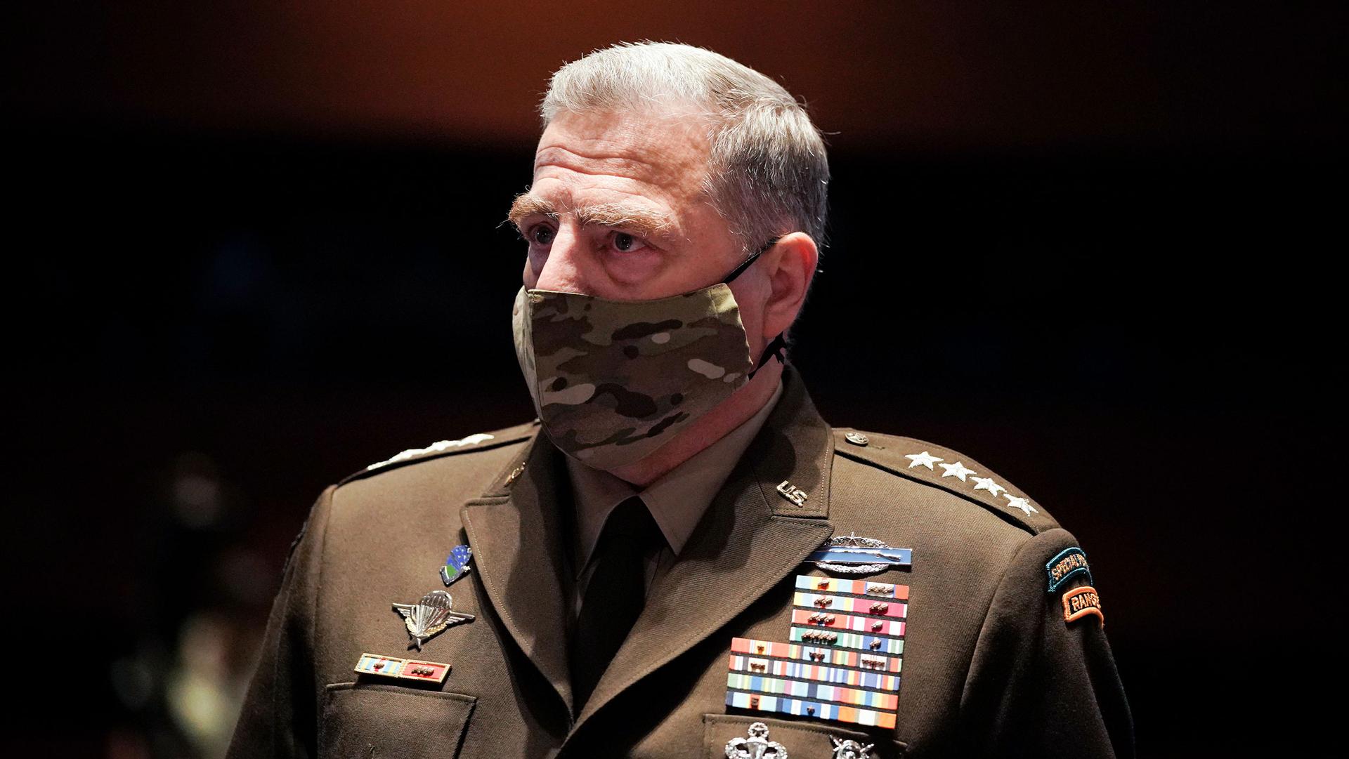 Chairman of the Joint Chiefs of Staff Gen. Mark Milley is shown wearing a camoflaged face mask and his military suit with medals across his chest.