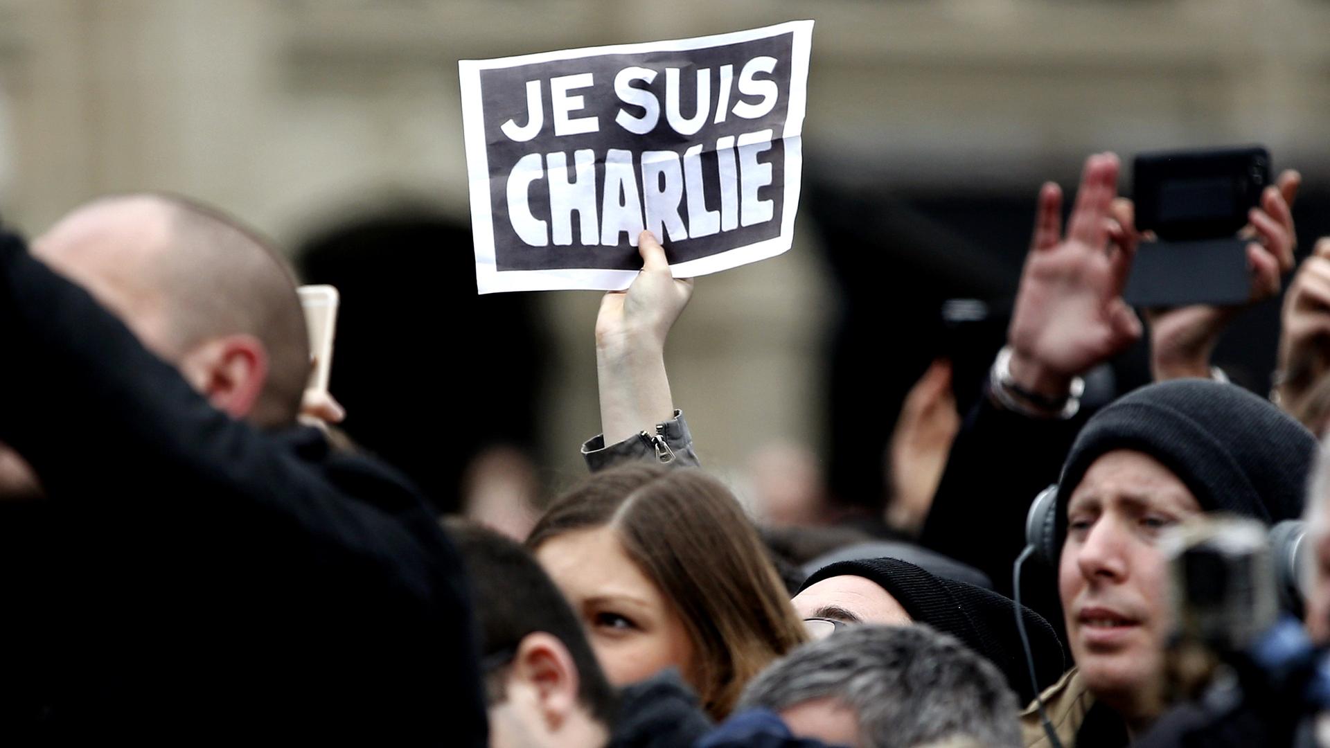 A person holds up a "Je Suis Charlie" ("I am Charlie") sign during a ceremony at Place de la Republique square to pay tribute to the victims of the 2015 shooting at the French satirical newspaper Charlie Hebdo, in Paris, France, Jan. 10, 2016. 
