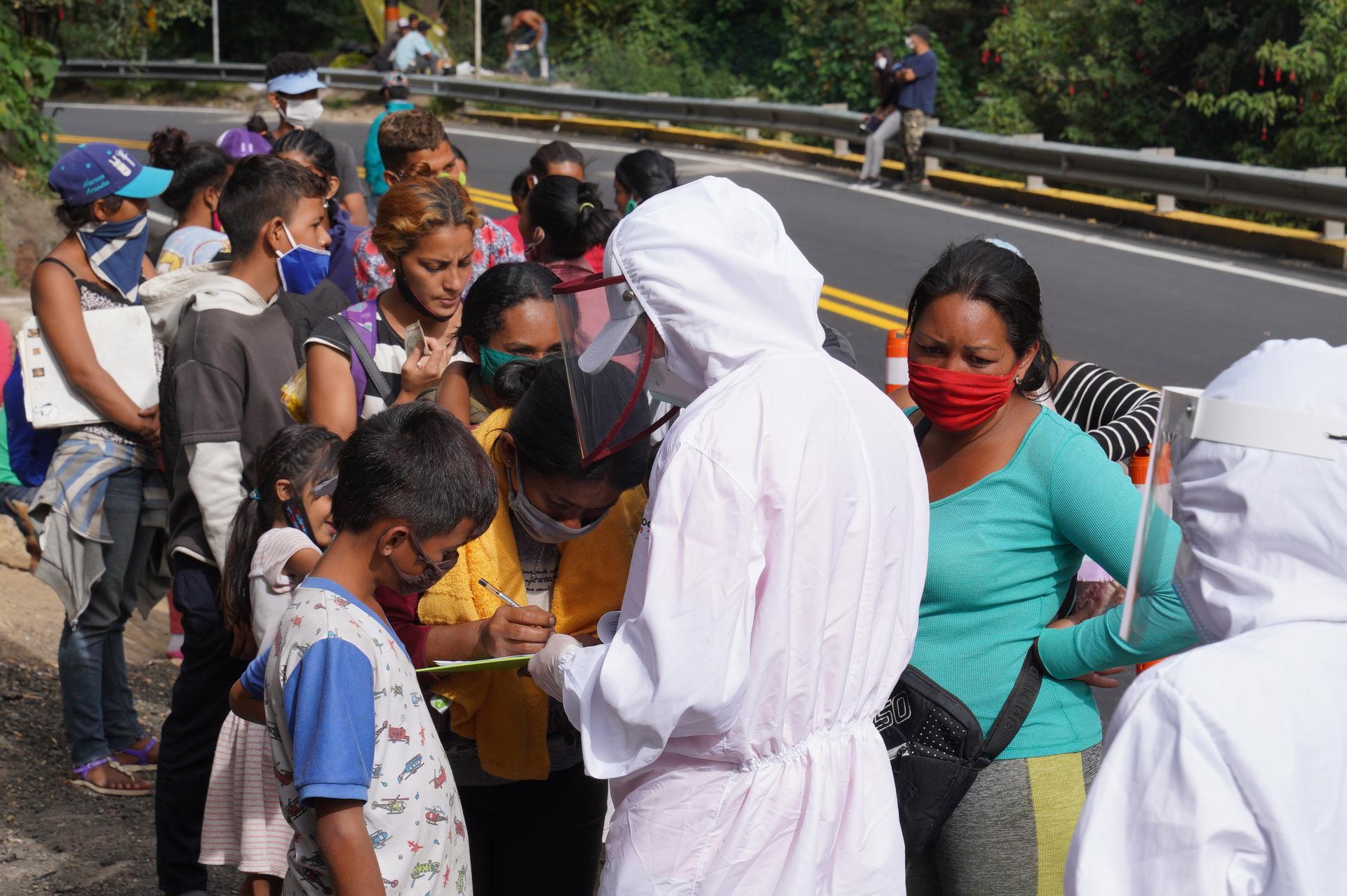 A humanitarian worker registers Venezuelan migrants arriving in Pamplona, Colombia, on Sept. 30. Social workers say that 200 migrants are passing through the country each day.