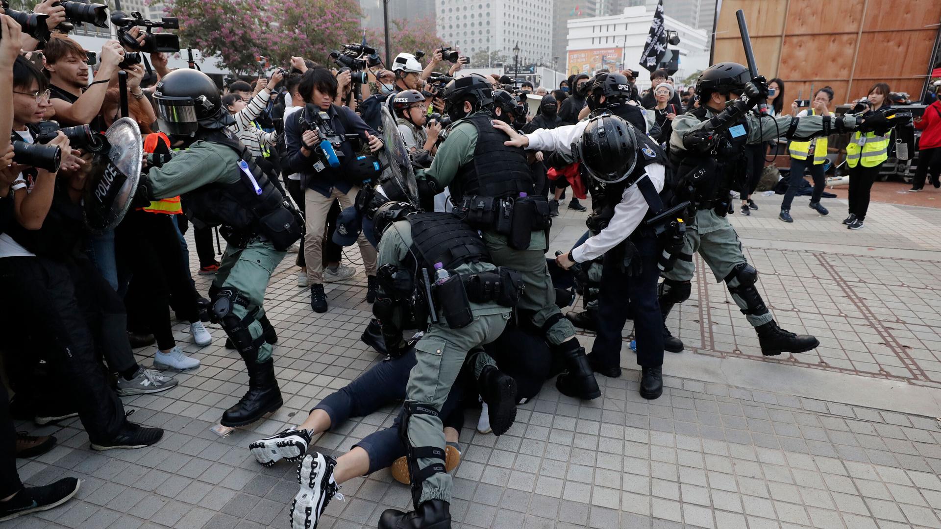 Riot police arrest protesters during a rally to show support for Uighurs and their fight for human rights. Thousands of demonstrators attended a rally to protest against China's policy on the Uighur minority, Hong Kong, Dec. 2019.