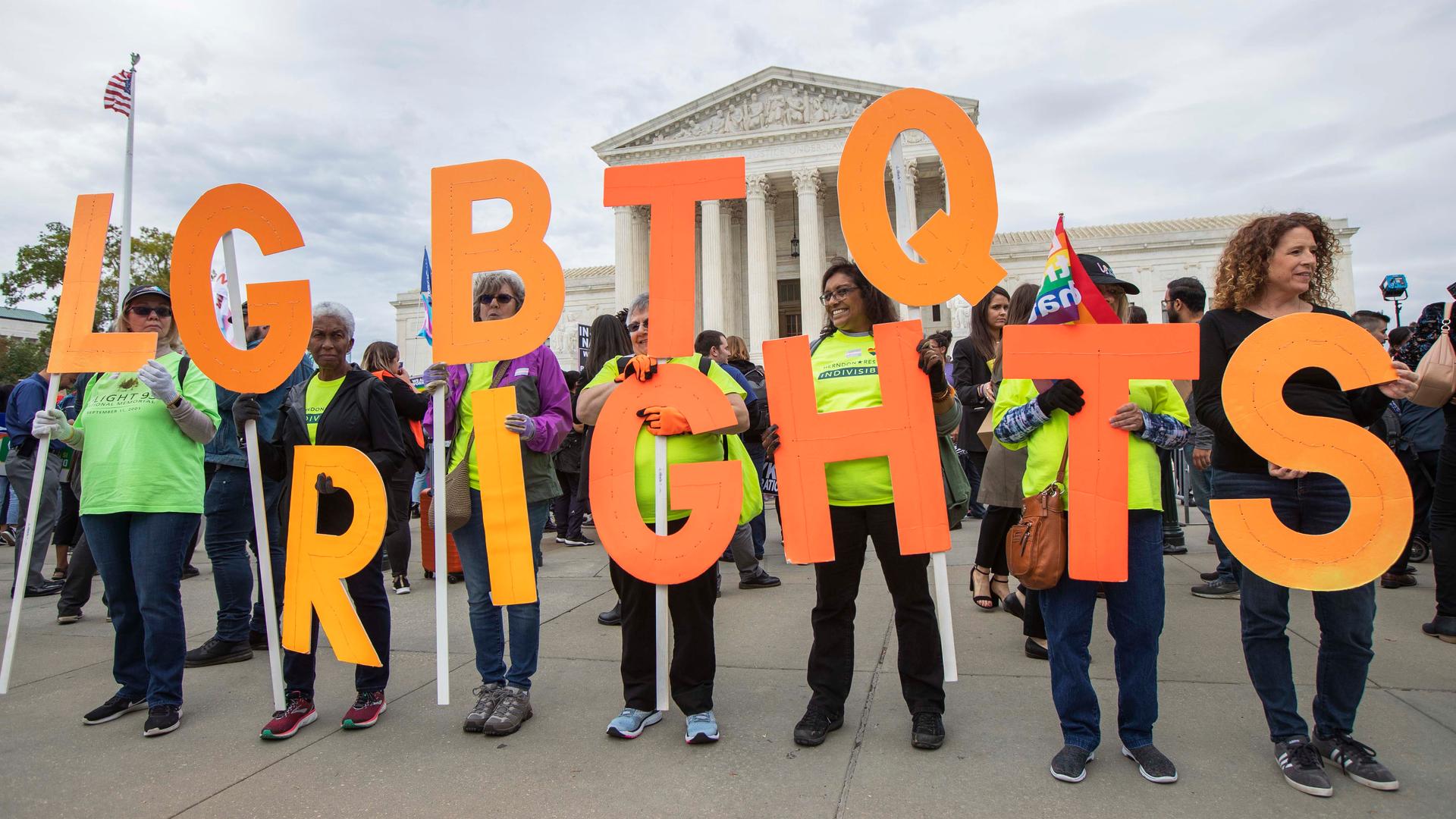 In this Oct. 8, 2019, file photo, supporters of LGBTQ rights hold placards in front of the U.S. Supreme Court in Washington, DC.