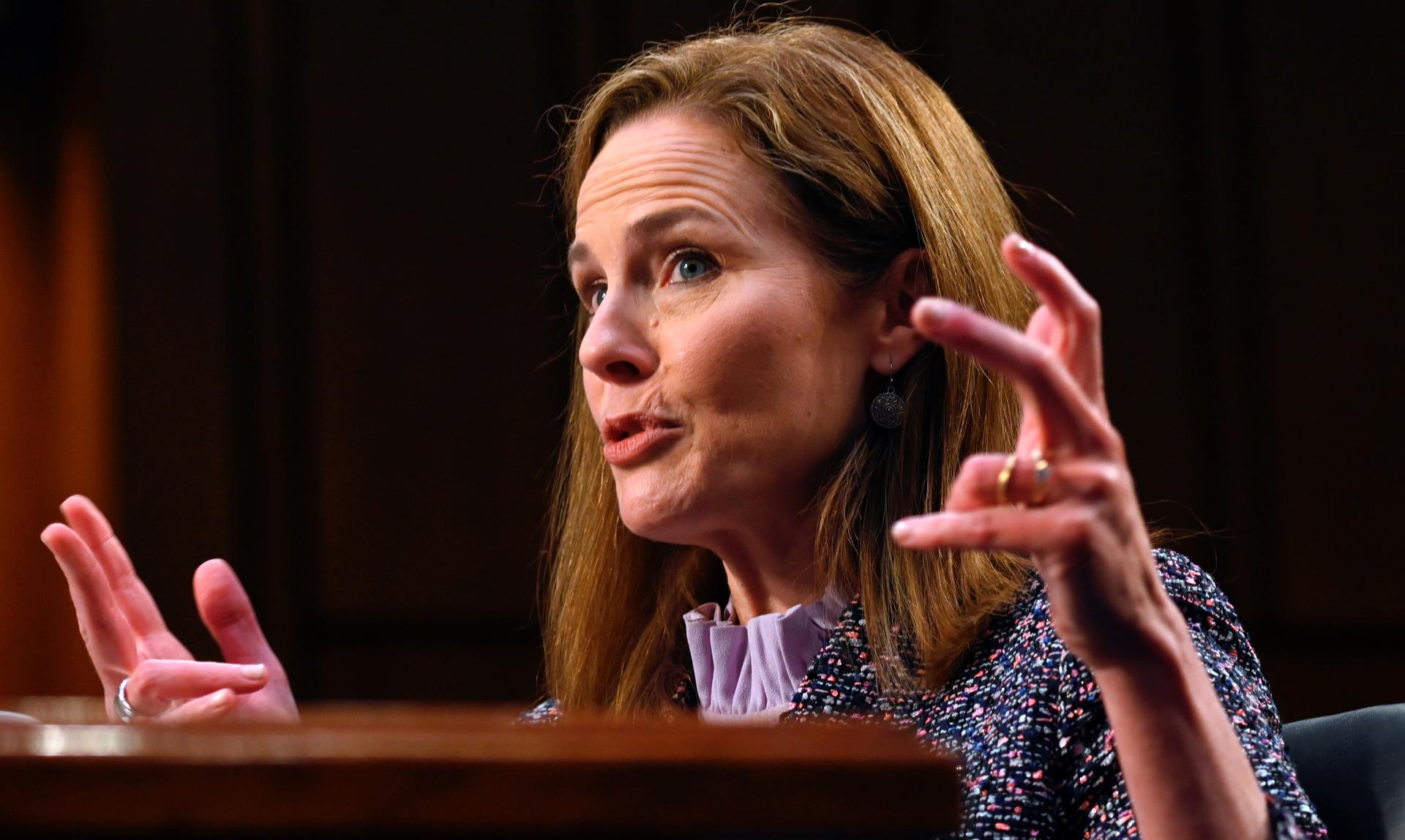 Judge Amy Coney Barrett speaks and gestures into a mic during the third day of her Senate confirmation hearing.  