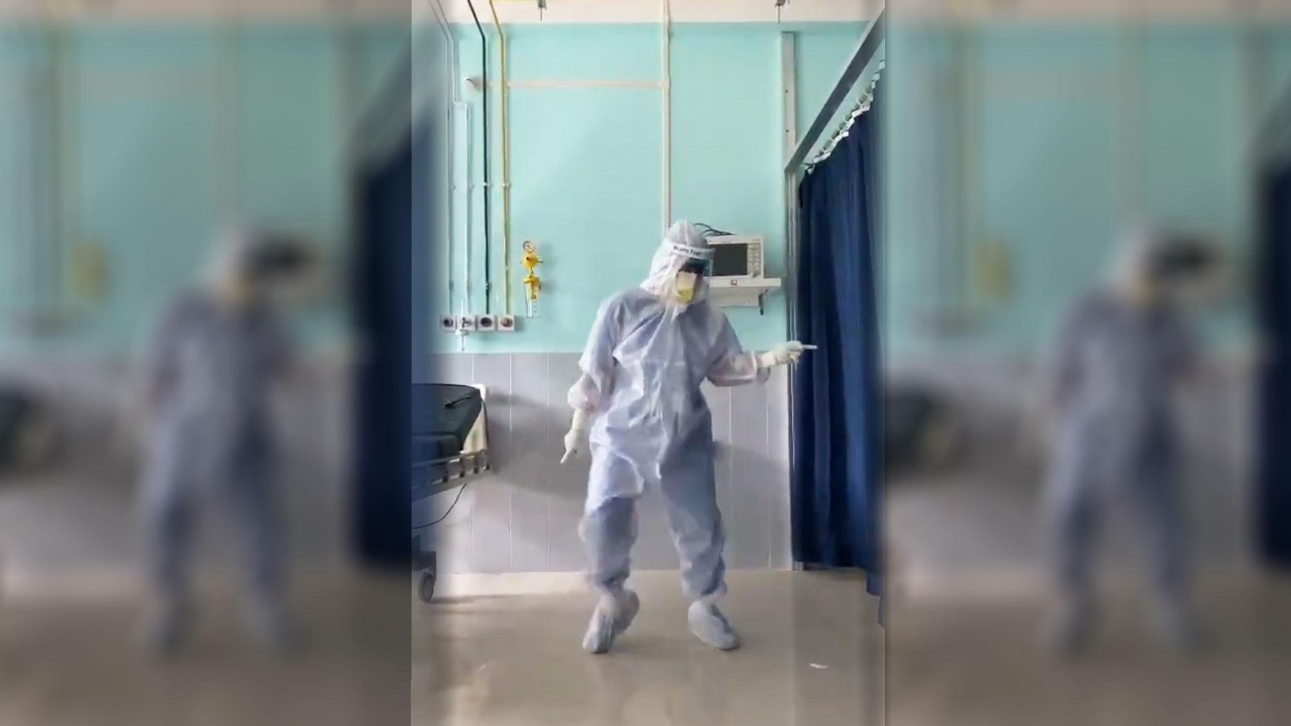 Dr. Arup Senapati is shown in full medical personal protective equipment and dancing in a hospital.