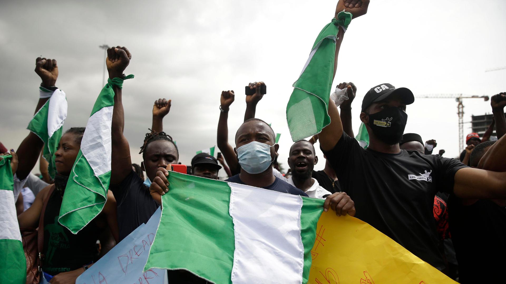 People hold banners as they demonstrate on the street to protest against police brutality in Lagos, Nigeria, Oct. 19, 2020.