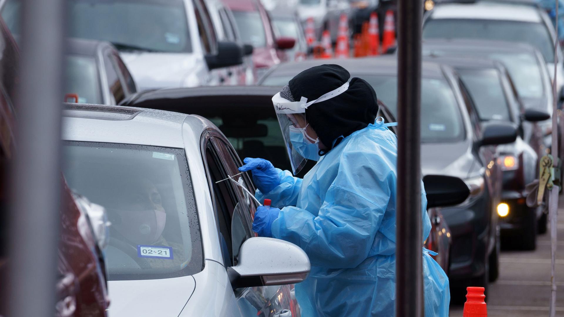 A nurse takes a swab sample at a drive-through coronavirus test site at the University of Texas El Paso in El Paso, Texas, Oct. 27, 2020.