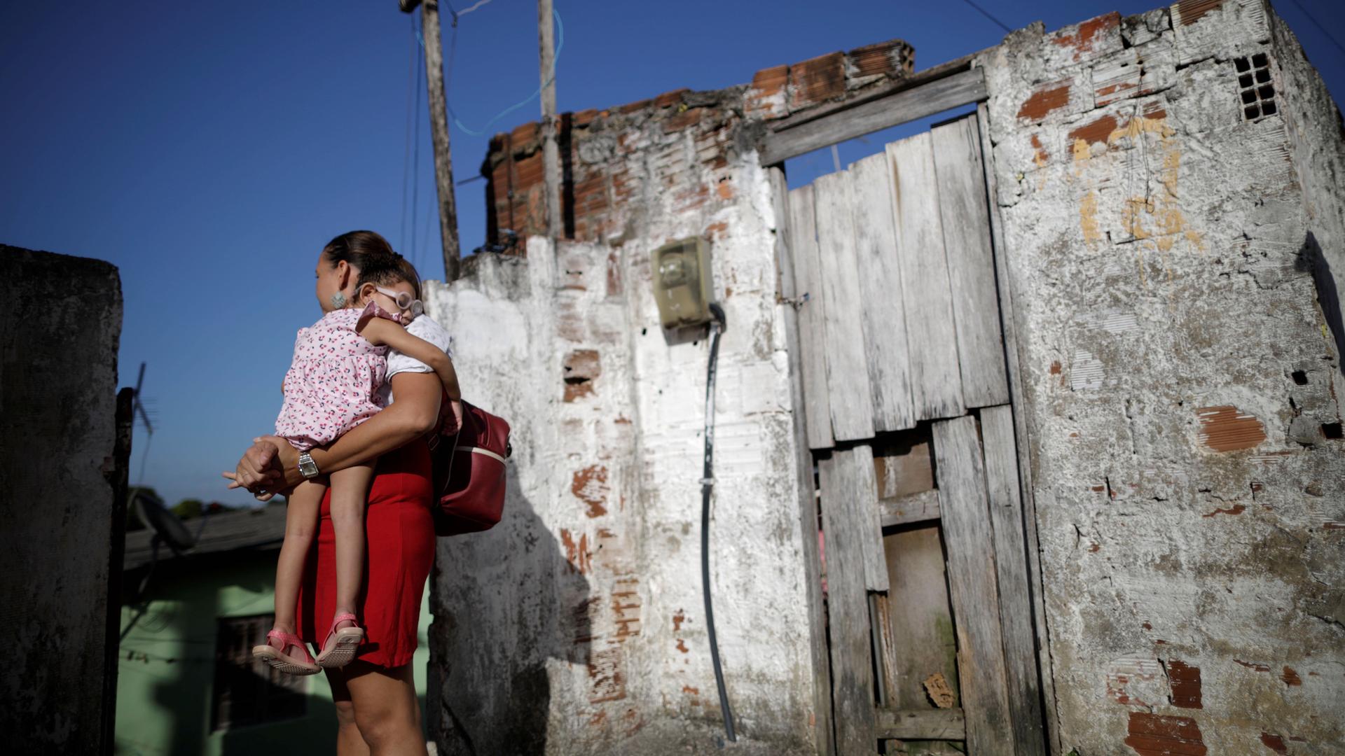 Gleyse Kelly da Silva, 28, holds her 2-year-old daughter Maria Giovanna at their house in Recife, Brazil, Aug. 8, 2018. 