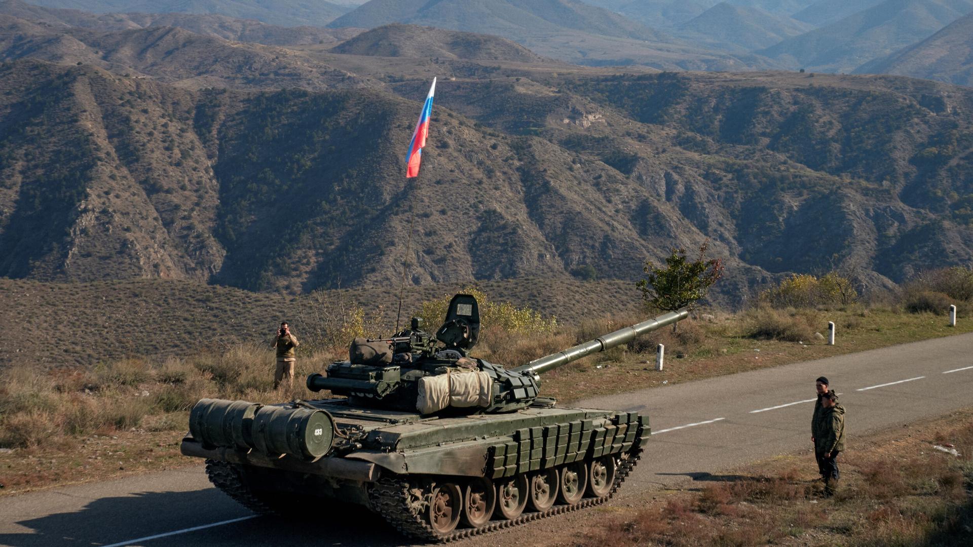Service members of Russian peacekeeping troops stand next to a tank near the border with Armenia, following the signing of a deal to end the military conflict between Azerbaijan and ethnic Armenian forces, in the region of Nagorno-Karabakh, Nov. 10, 2020.
