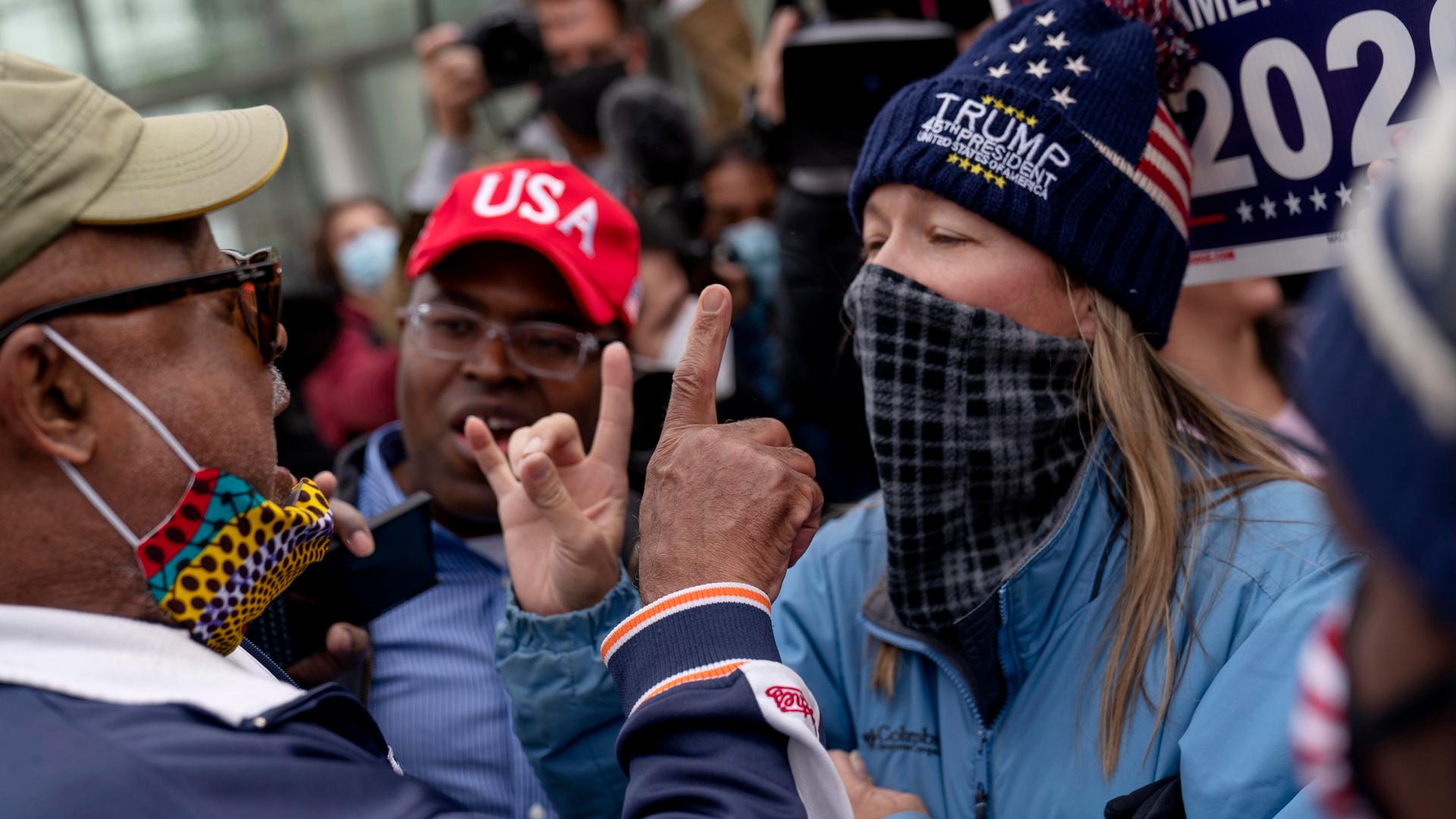 Trump supporters at right argue with a counterprotester at left as they protest election results outside the central counting board at the TCF Center in Detroit, Michigan, Nov. 5, 2020.