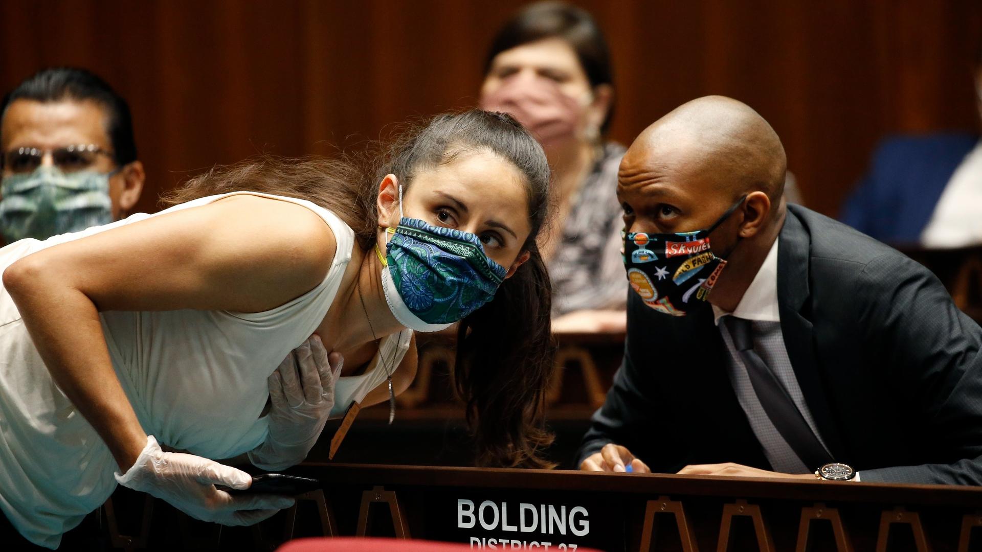 Rep. Athena Salman, left, talks with Rep. Reginald Bolding during a vote in the Arizona House of Representatives to end the 2020 session due to the coronavirus, May 19, 2020, in Phoenix. 