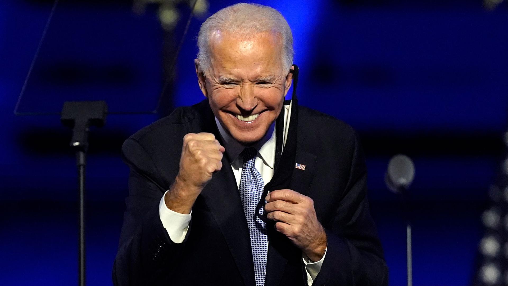 President-elect Joe Biden is shown wearing a dark suit and smiling while holding his fists up like a boxer.