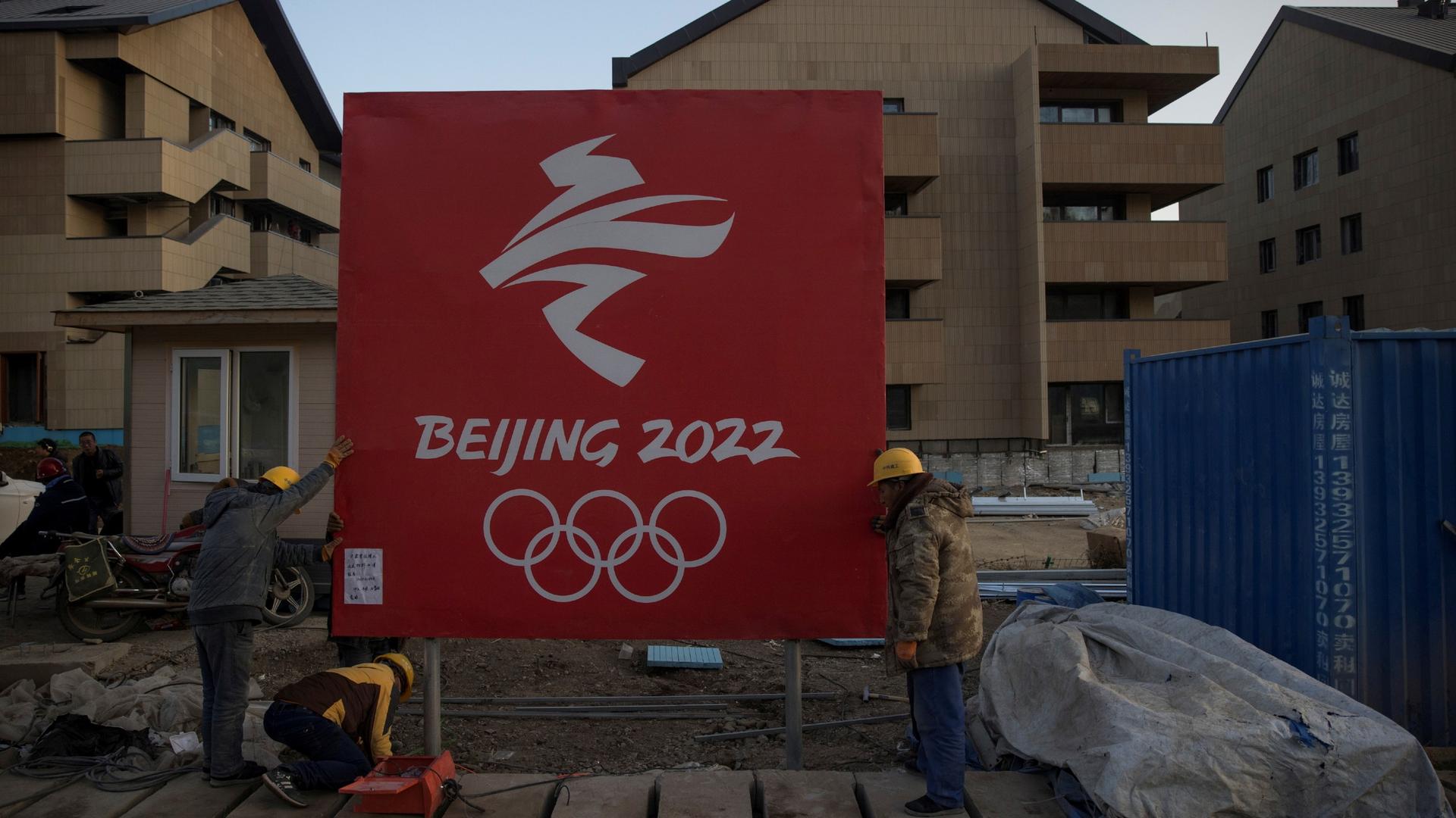 Workers move a sign at the Olympic Village for the 2022 Winter Olympics in the Chongli district of Zhangjiakou, Hebei province, China, Oct. 29, 2020.