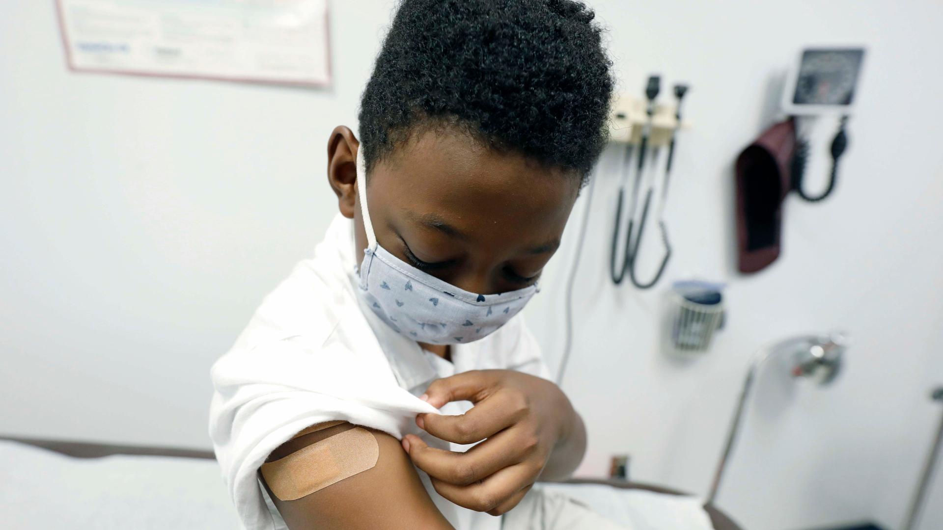 Jeremiah Young, 11, examines his bandage covering during an appointment with Dr. Janice Bacon at the Community Health Care Center on the Tougaloo College campus in Tourgaloo, Miss., Aug. 14, 2020.
