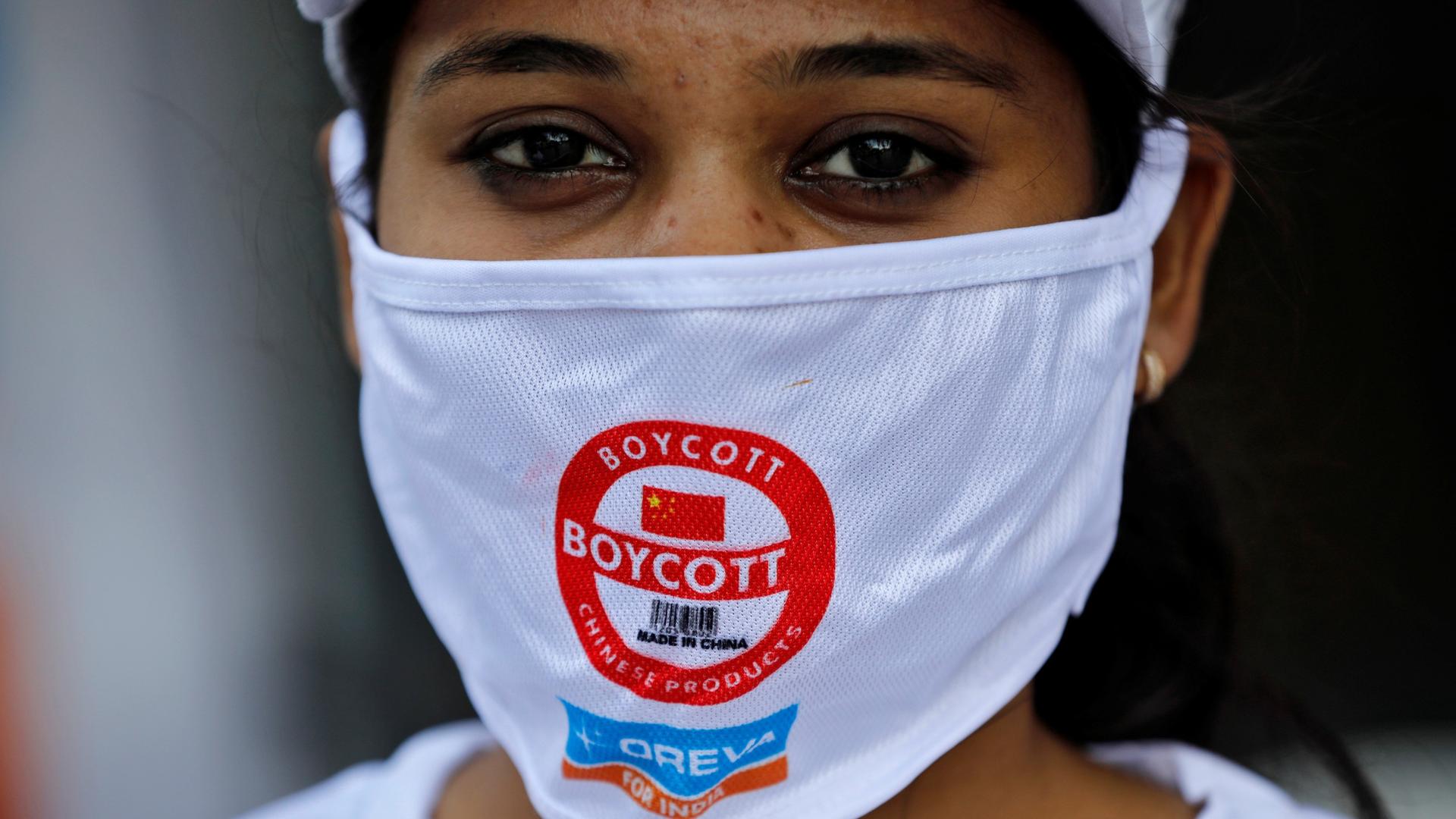 A demonstrator wearing a protective face mask with a message attends a protest demanding to boycott China-made products.