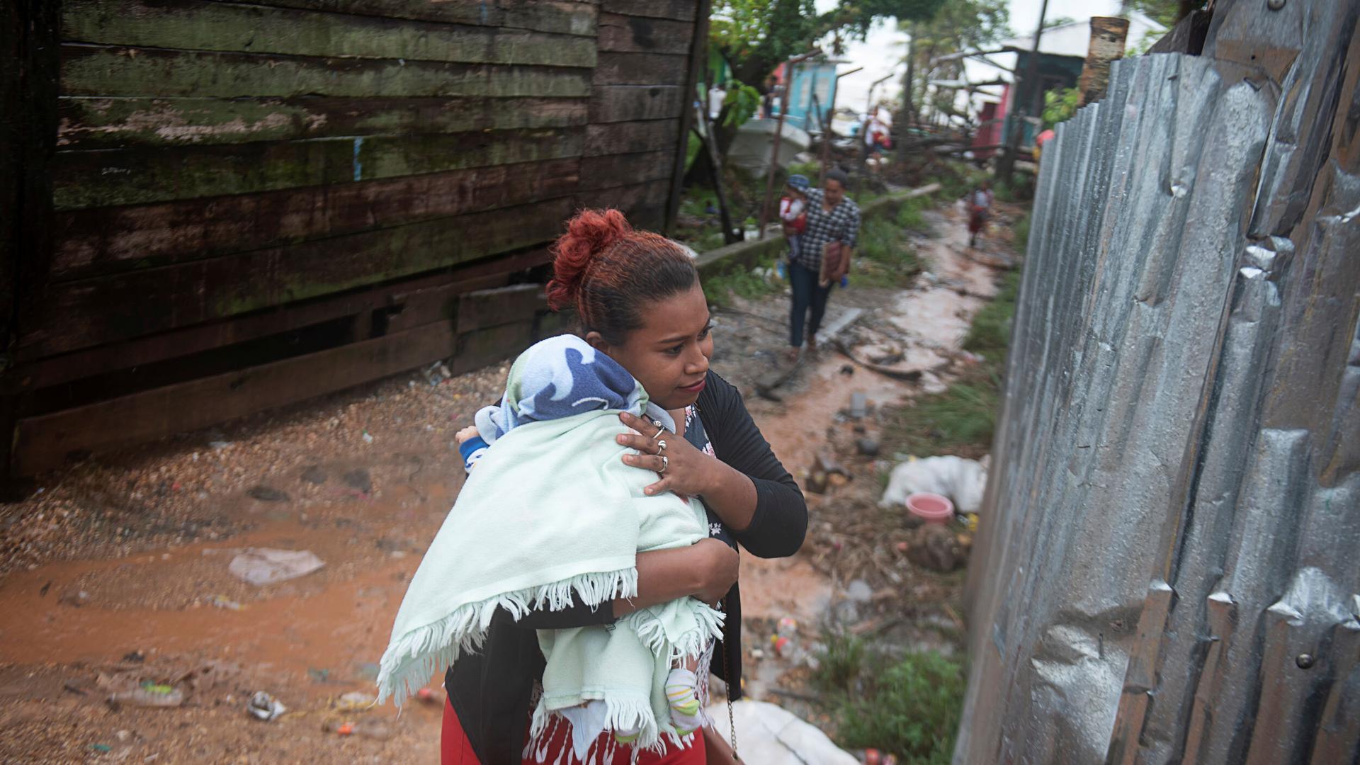 A woman protects her baby from the rain as Hurricane Iota approaches Puerto Cabezas, Nicaragua, Nov. 16, 2020.